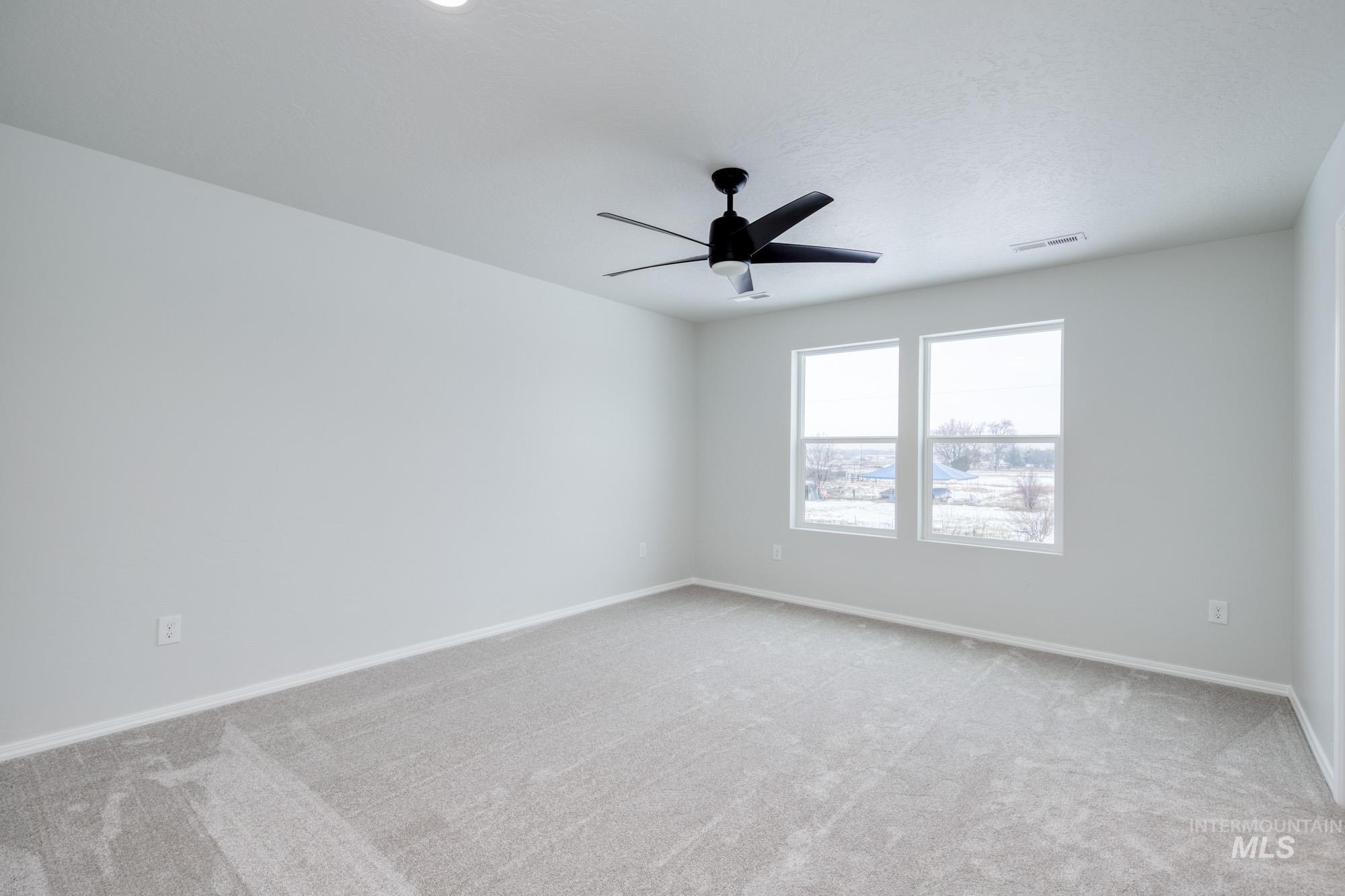 Empty room featuring light carpet and ceiling fan