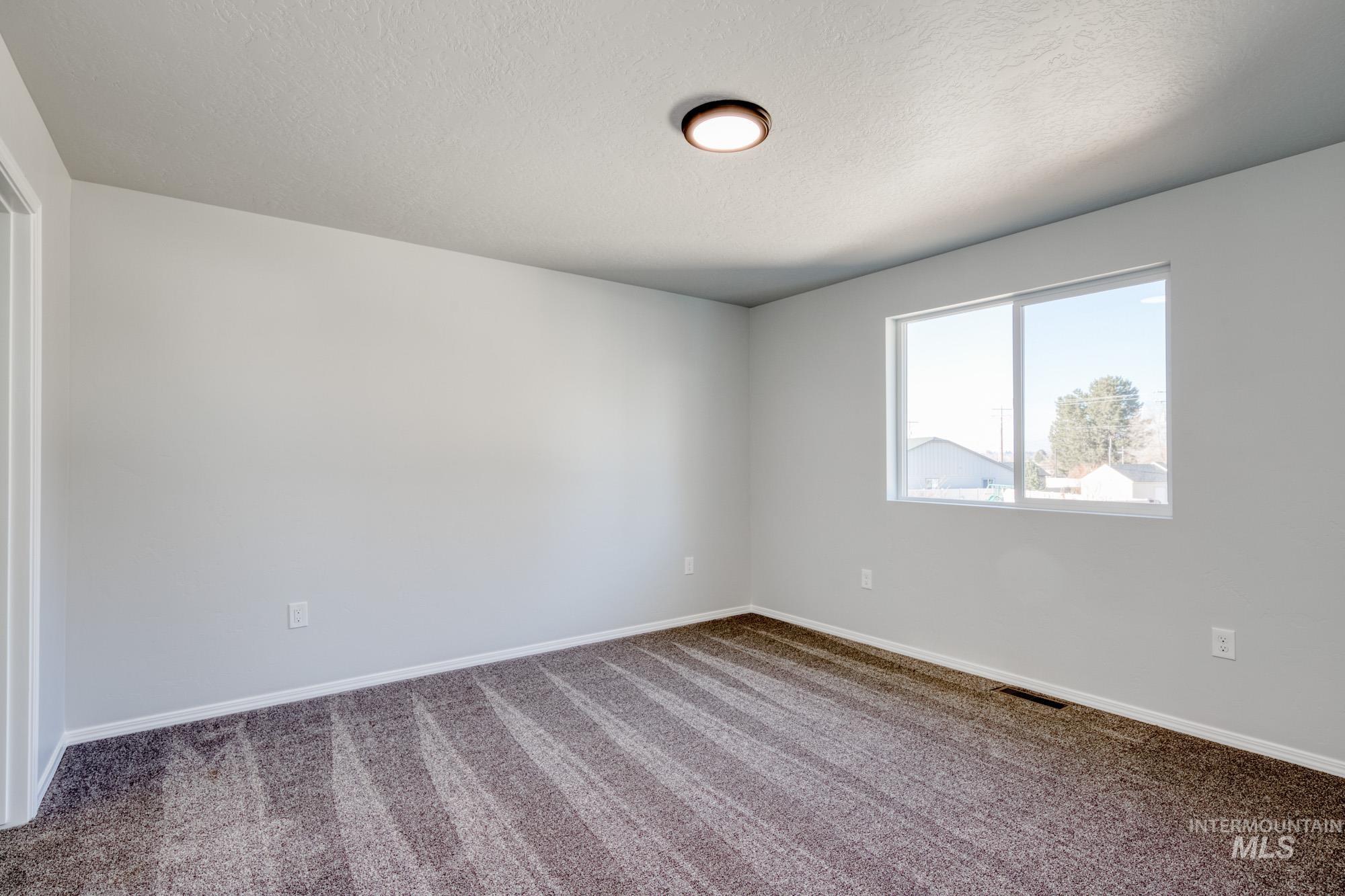 Spare room with carpet flooring and a textured ceiling