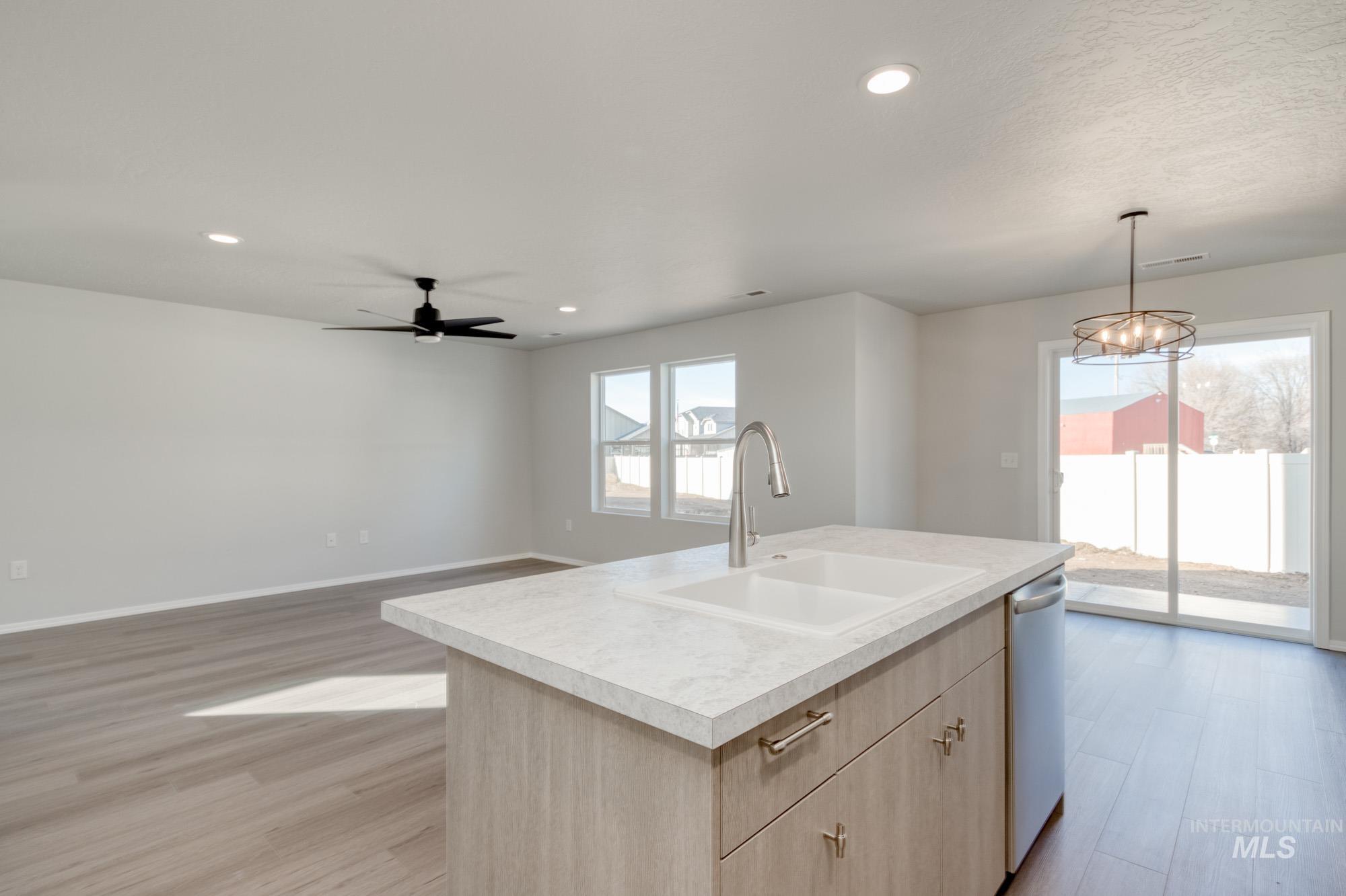 Kitchen featuring light brown cabinets, pendant lighting, light wood-style floors, light countertops, and recessed lighting