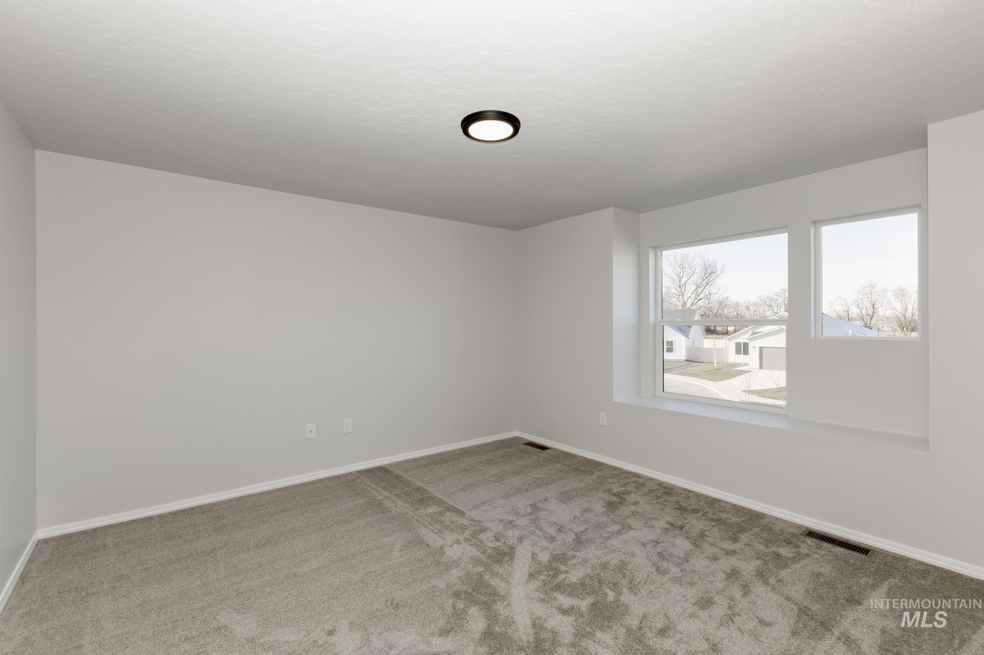 Carpeted spare room with baseboards