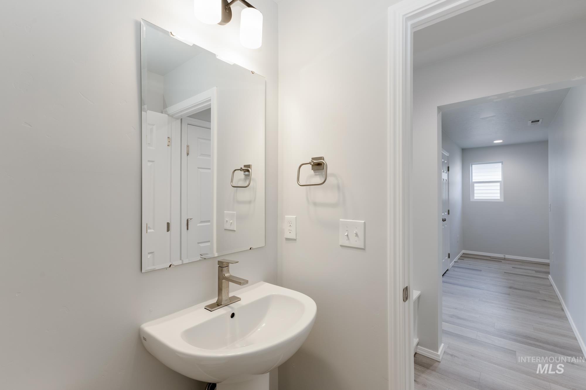 Bathroom featuring baseboards and light wood-style flooring
