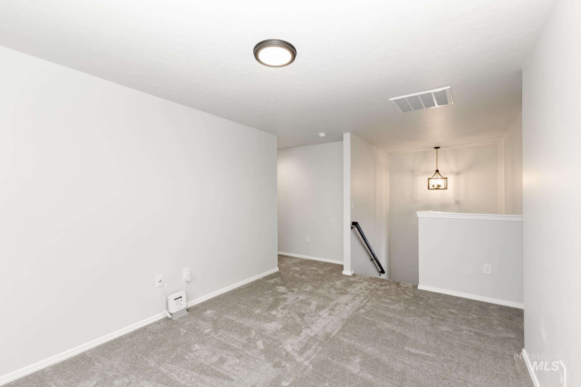 Carpeted empty room featuring baseboards