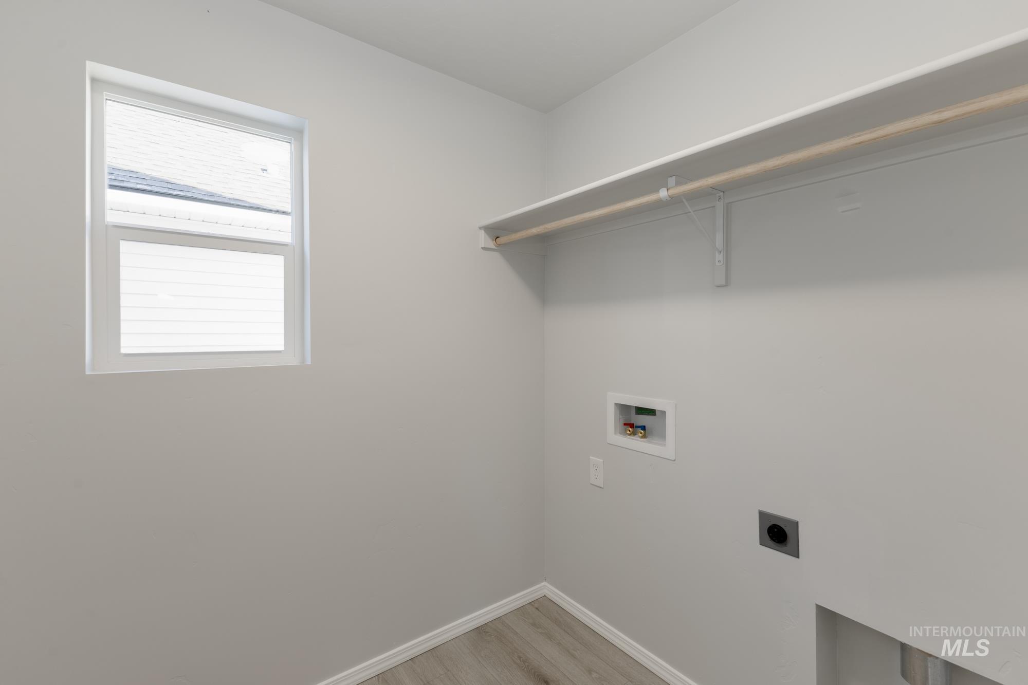Laundry room featuring light wood-style floors, washer hookup, and hookup for an electric dryer