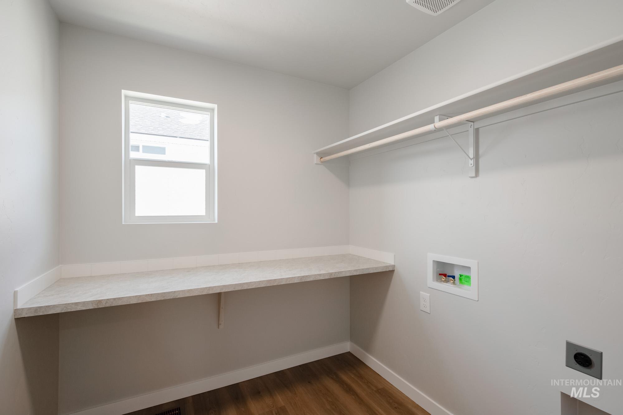 Laundry room featuring dark wood finished floors, hookup for a washing machine, and electric dryer hookup