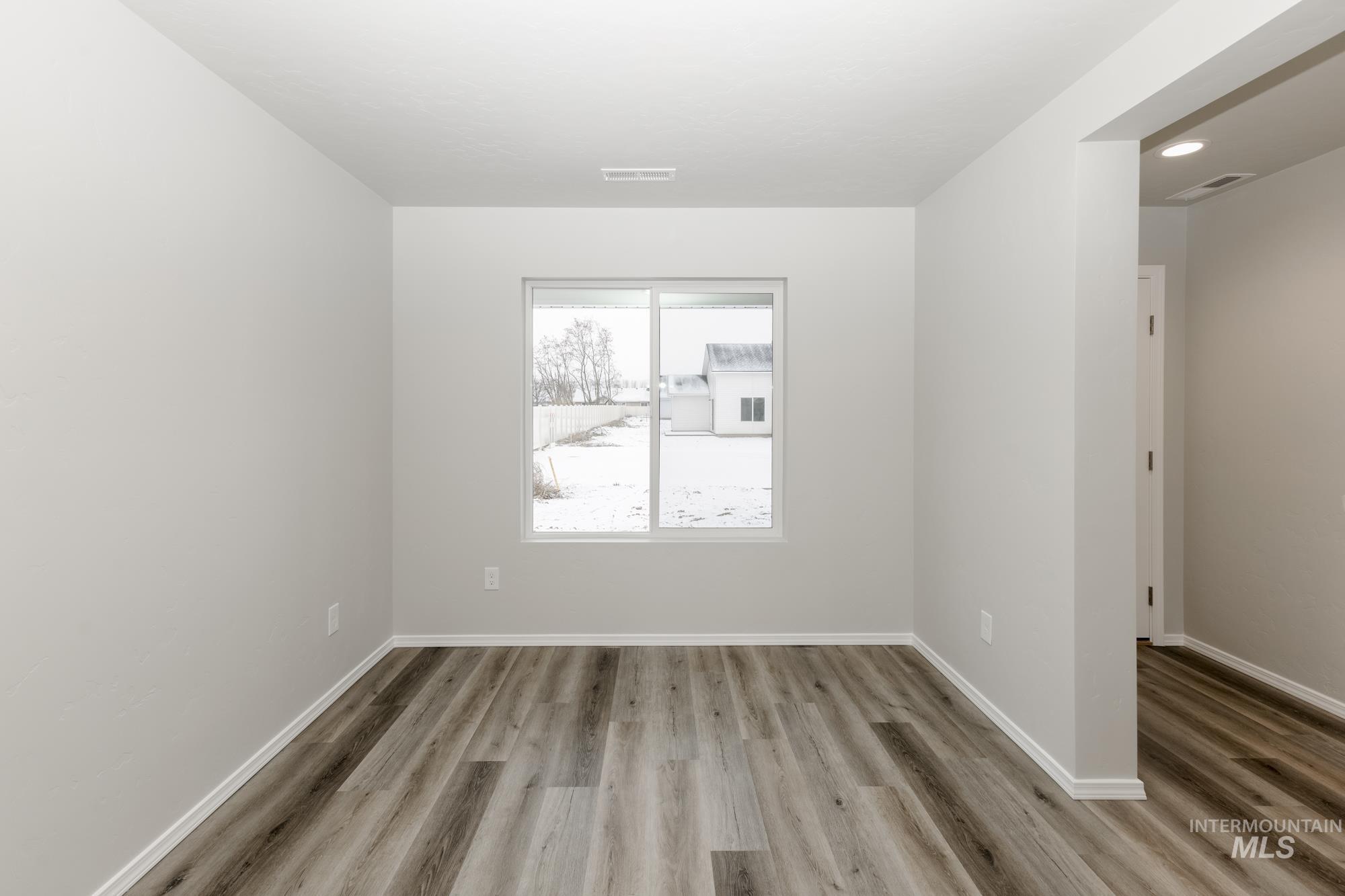 Spare room featuring baseboards and light wood-style floors