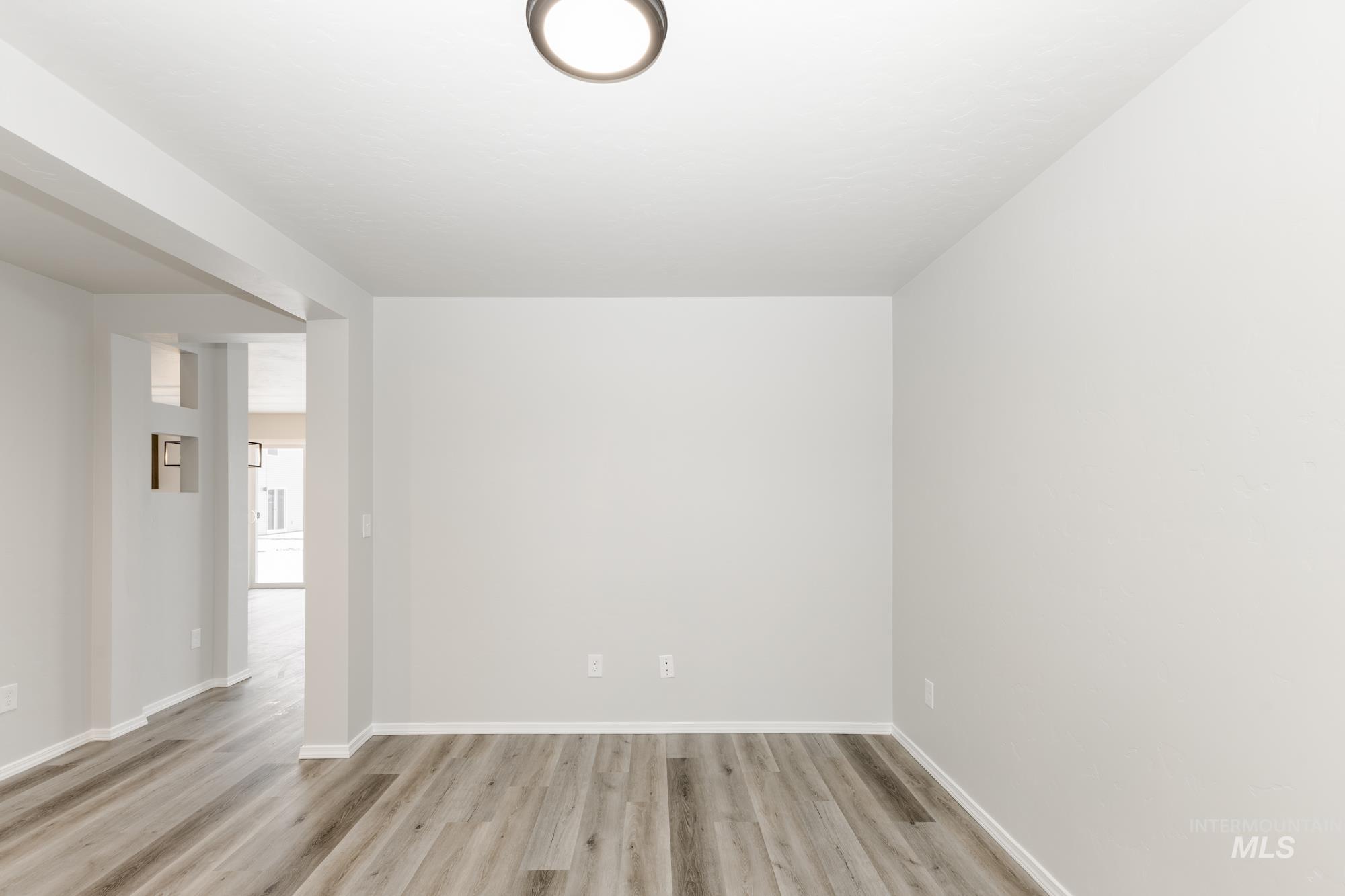 Unfurnished room with baseboards and light wood-type flooring