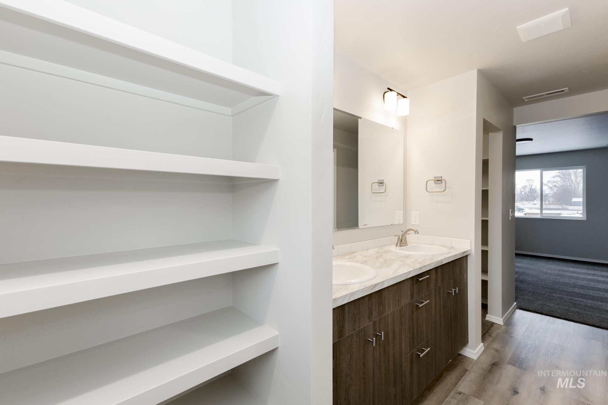 Bathroom featuring double vanity, light wood finished floors, and built in features