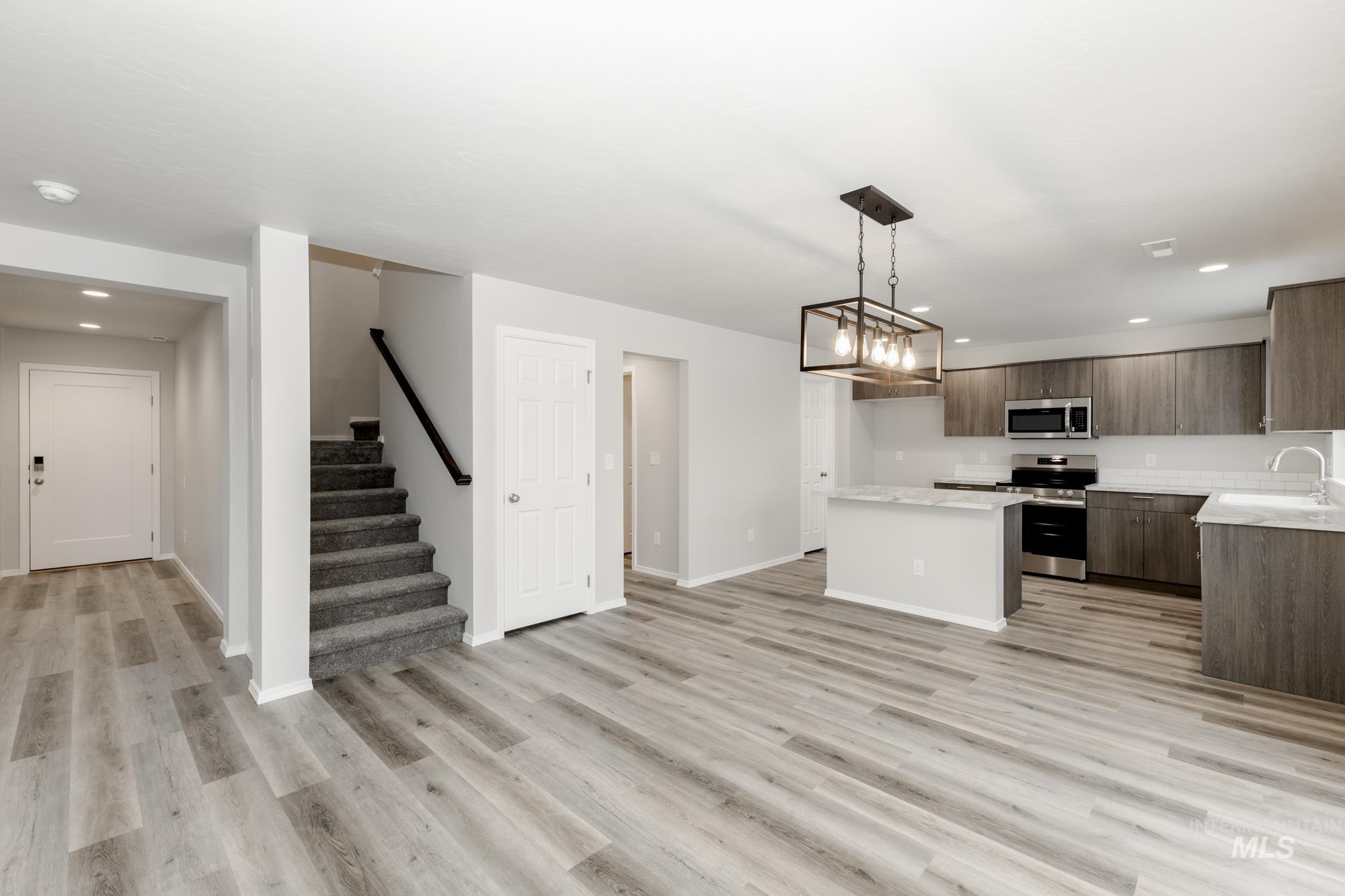 Kitchen featuring recessed lighting, appliances with stainless steel finishes, a center island, hanging light fixtures, and modern cabinets