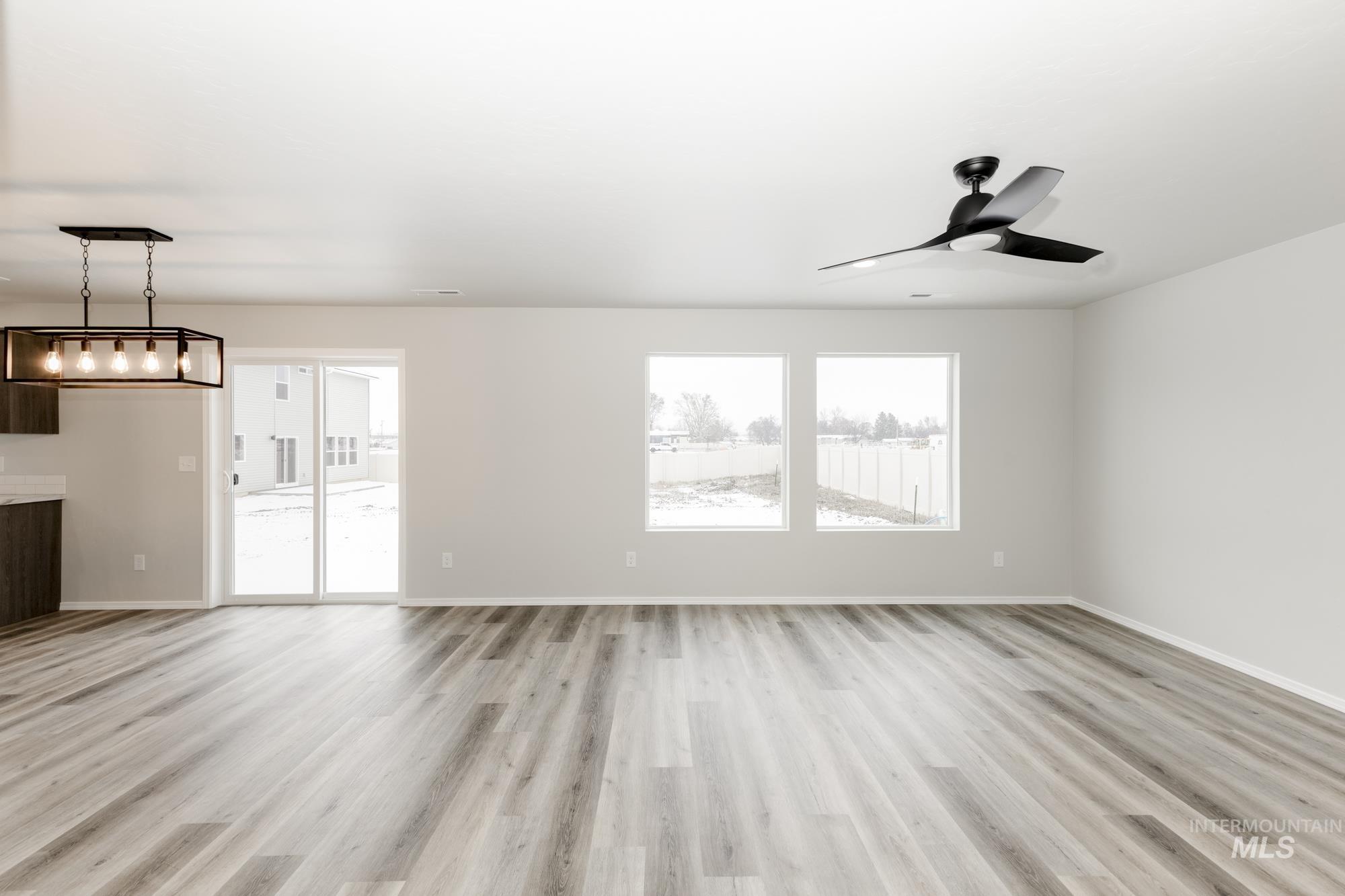 Unfurnished living room with light wood-type flooring and ceiling fan
