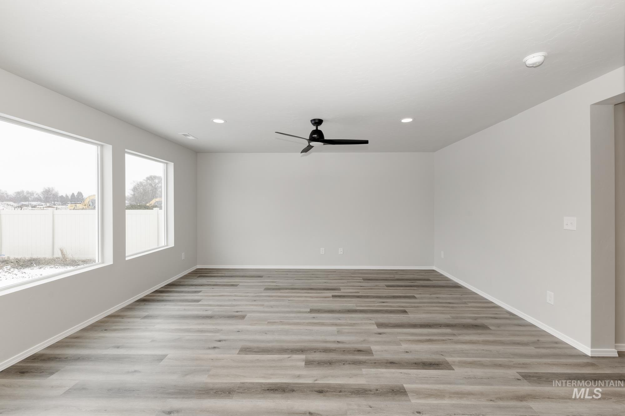 Empty room with light wood-style floors, a ceiling fan, and recessed lighting