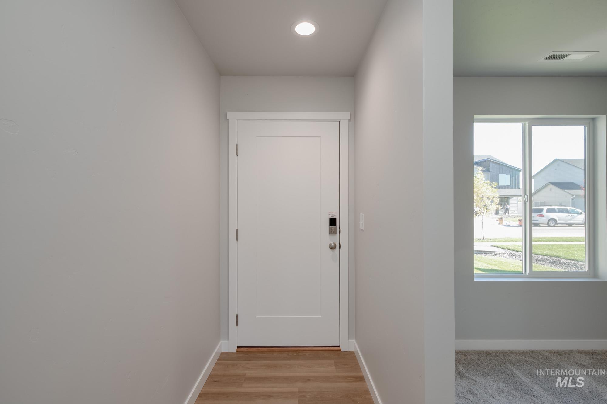 Doorway with recessed lighting and wood finished floors