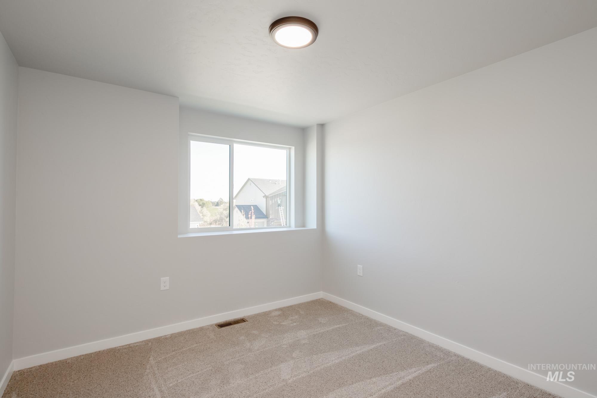 Carpeted empty room with baseboards