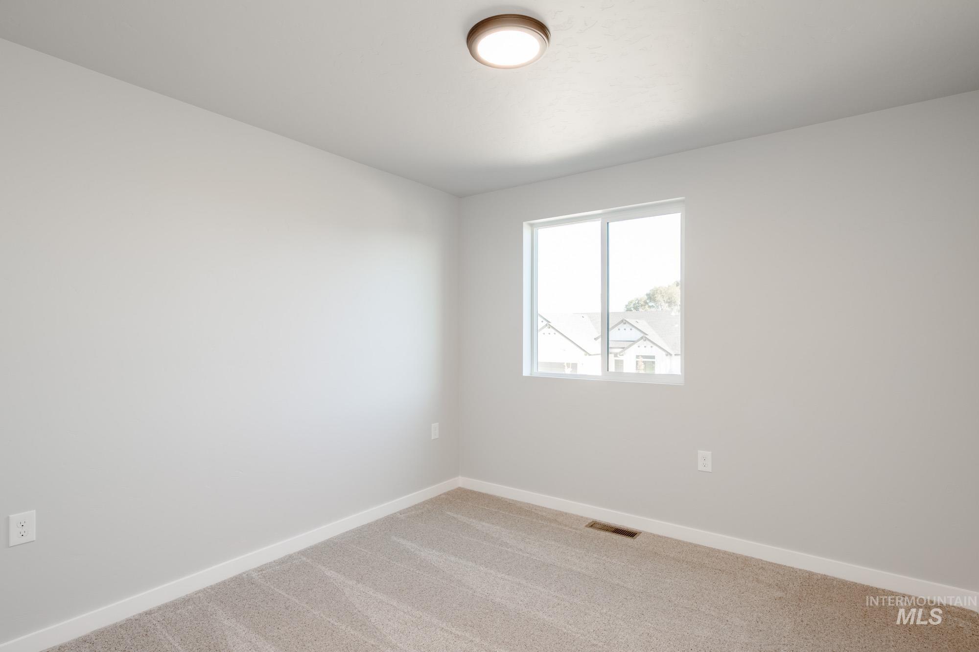Empty room with carpet and baseboards