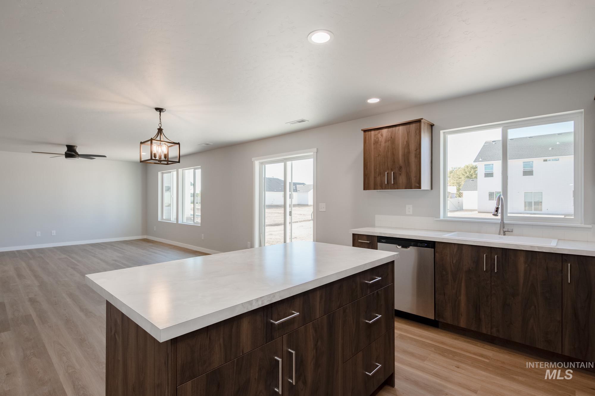 Kitchen with light wood-style floors, a center island, plenty of natural light, and recessed lighting