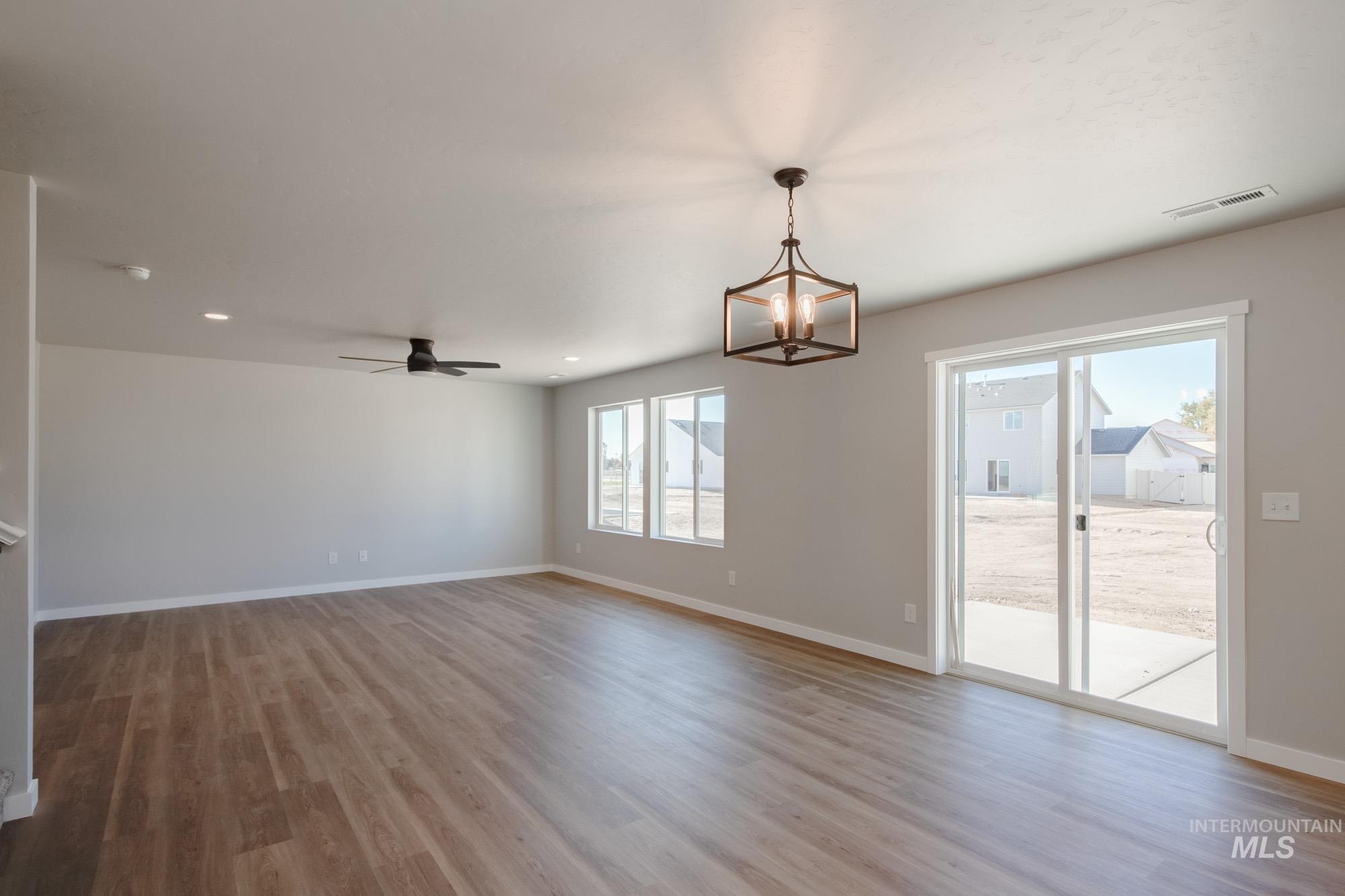 Unfurnished room featuring light wood-style floors, a chandelier, ceiling fan, and recessed lighting