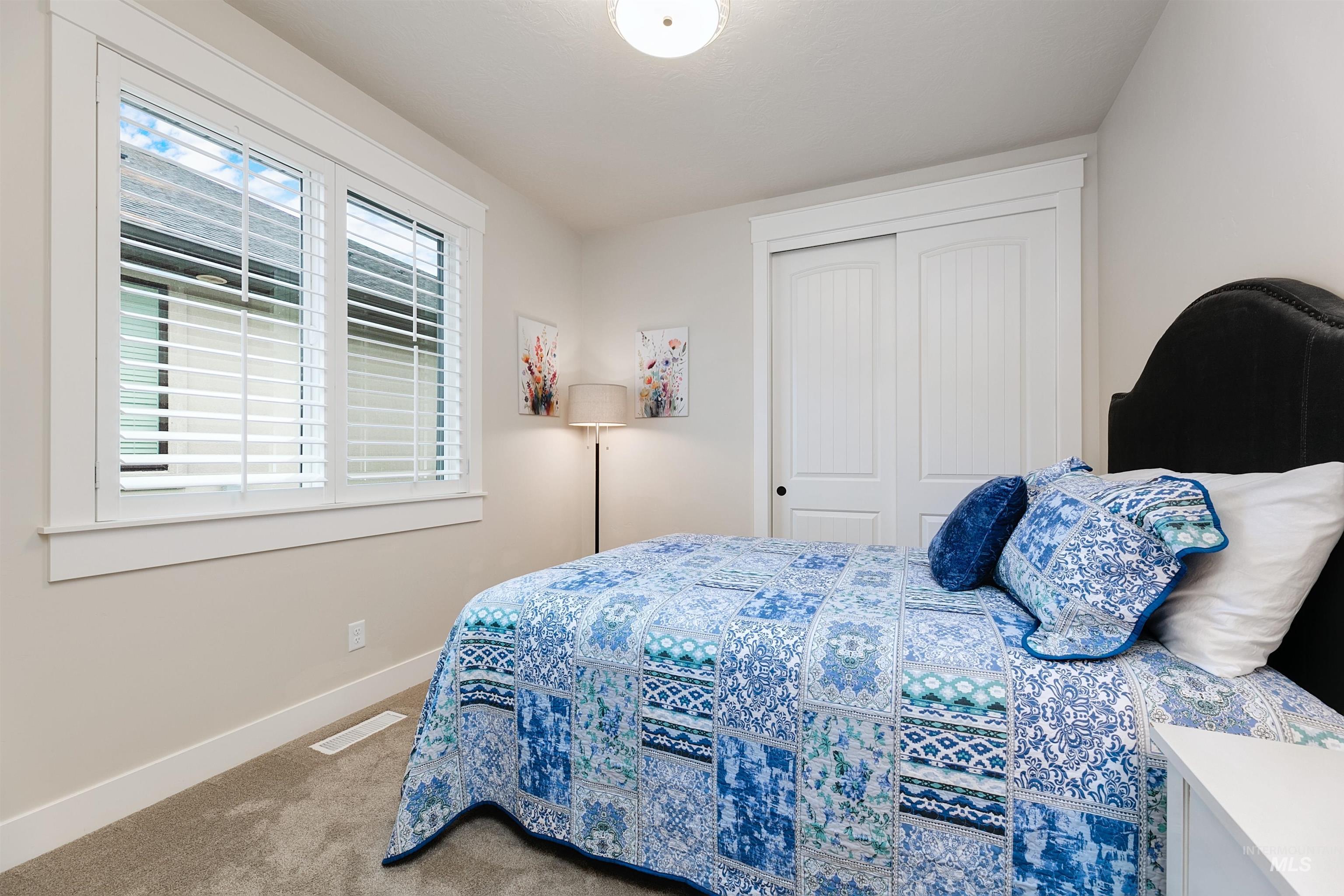 Carpeted bedroom with baseboards and a closet