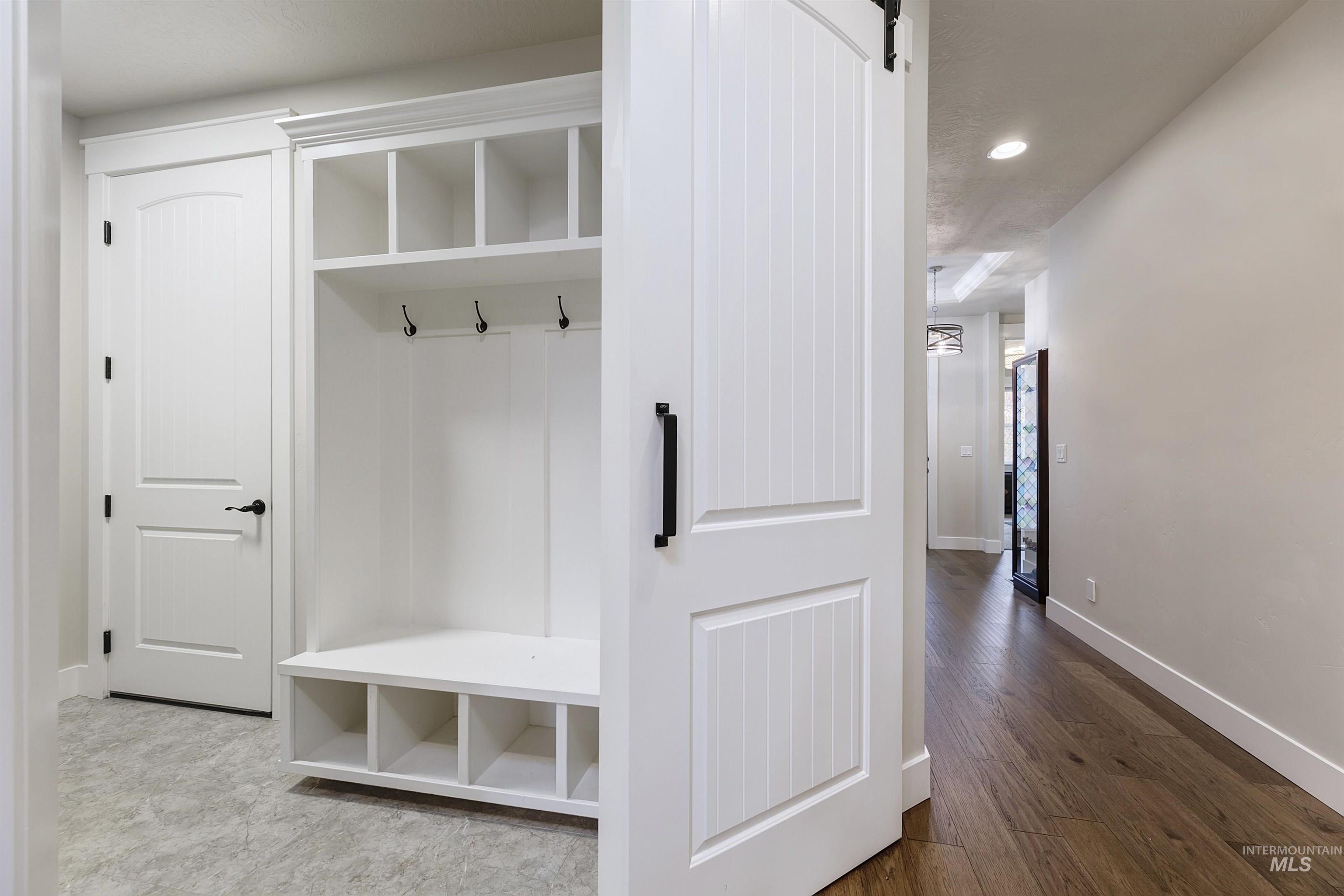 Mudroom with dark wood finished floors, recessed lighting, and a barn door