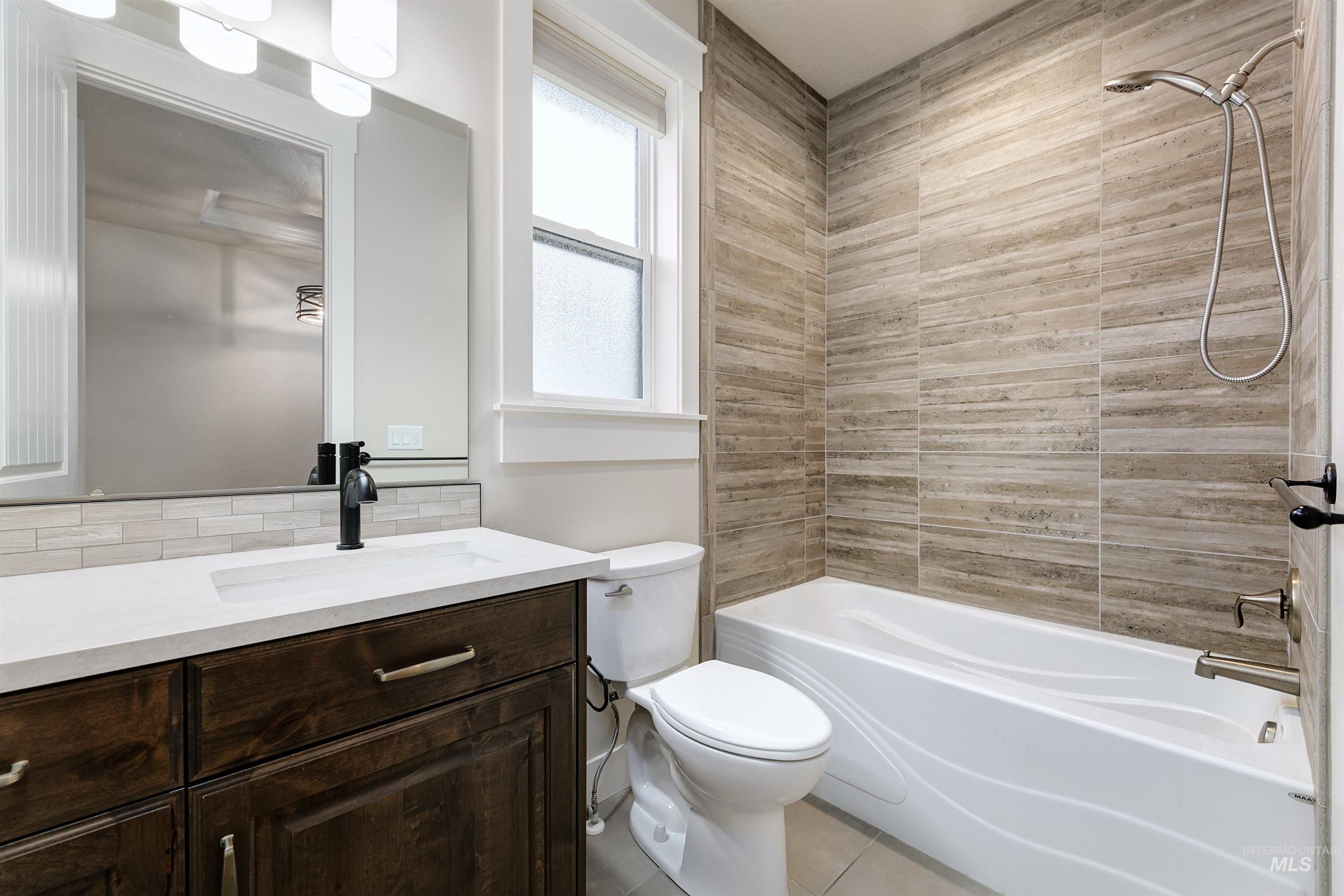 Full bathroom with vanity, shower / tub combination, and light tile patterned flooring