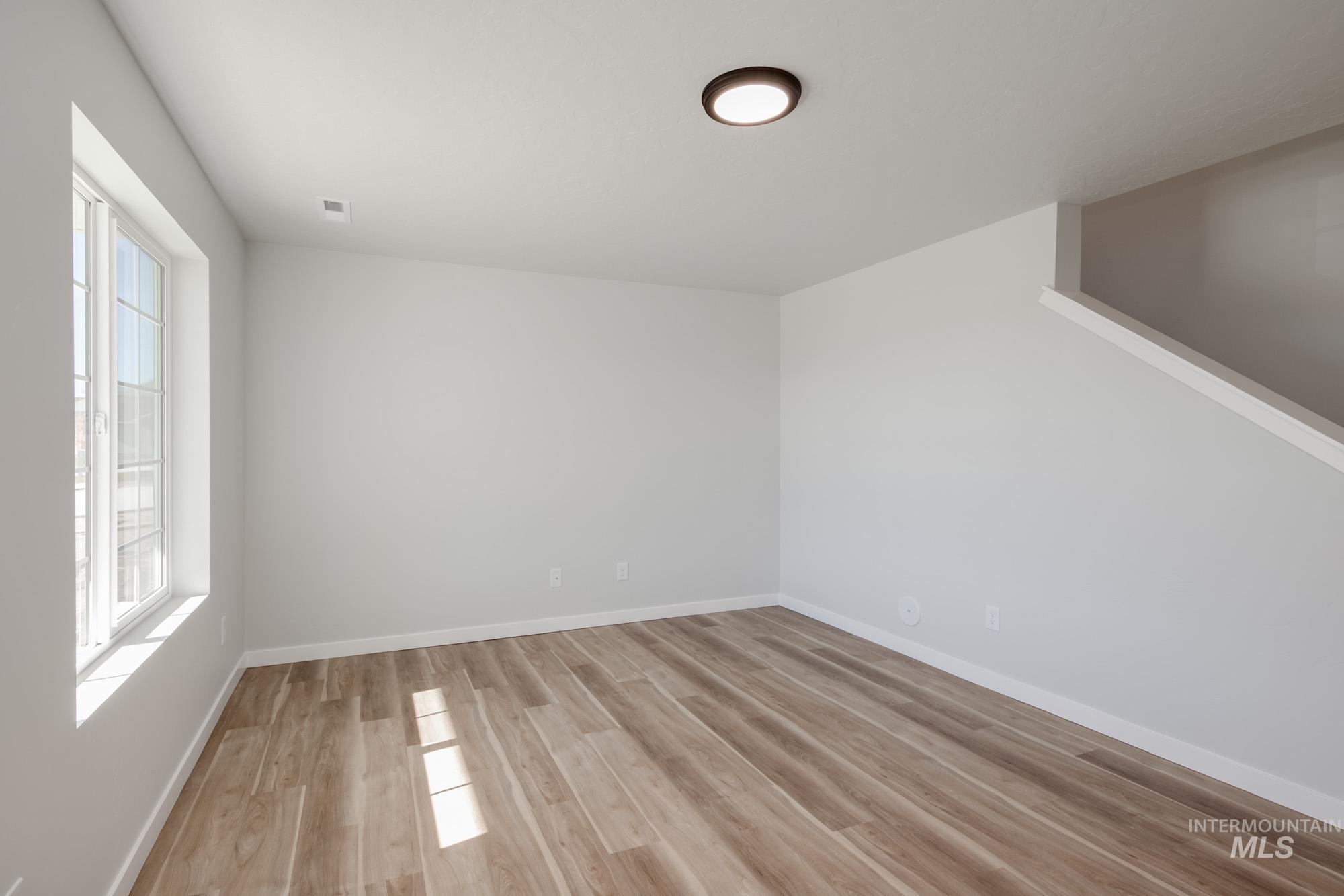 Spare room featuring baseboards and light wood finished floors
