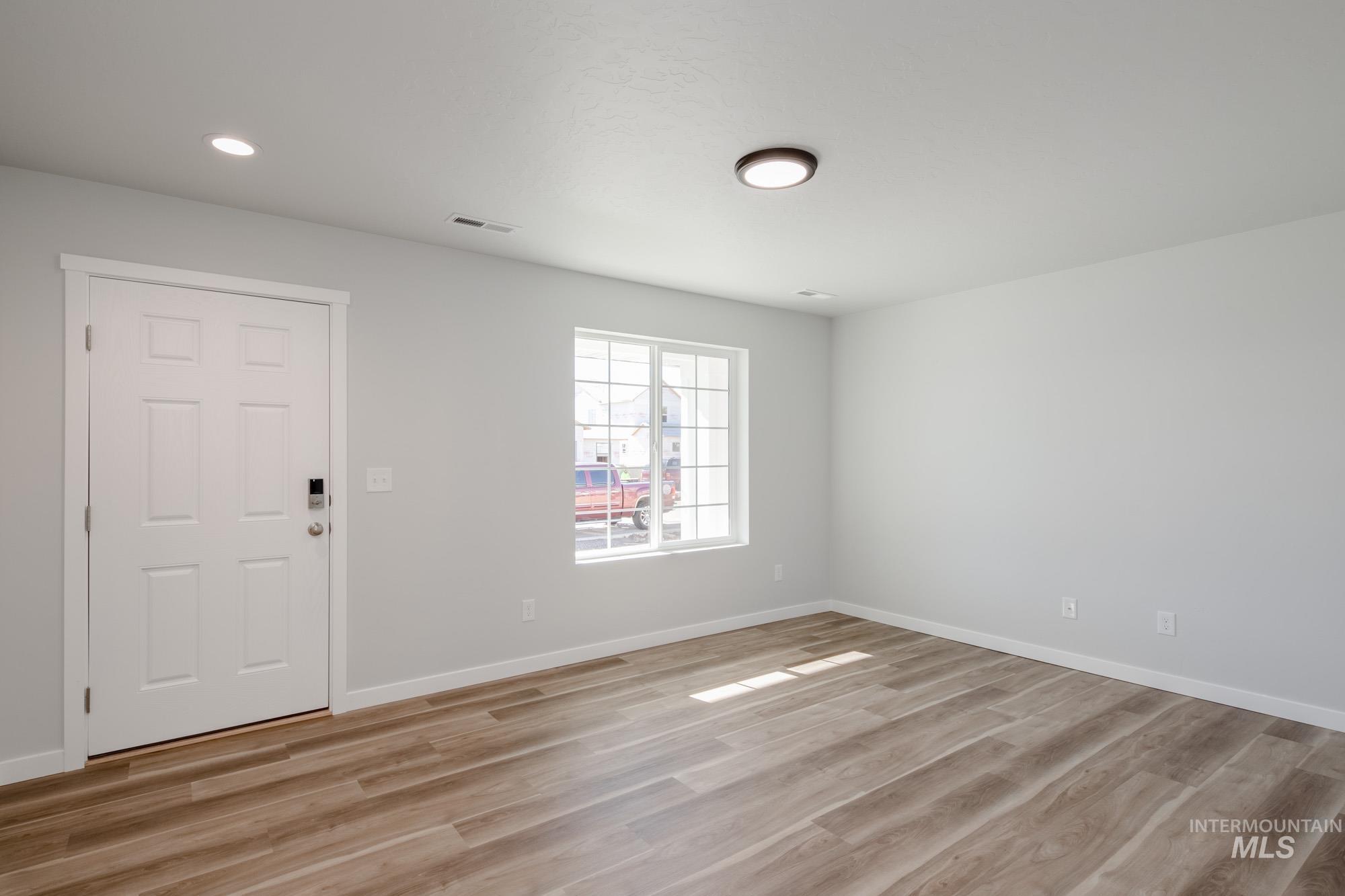 Spare room with light wood finished floors and recessed lighting