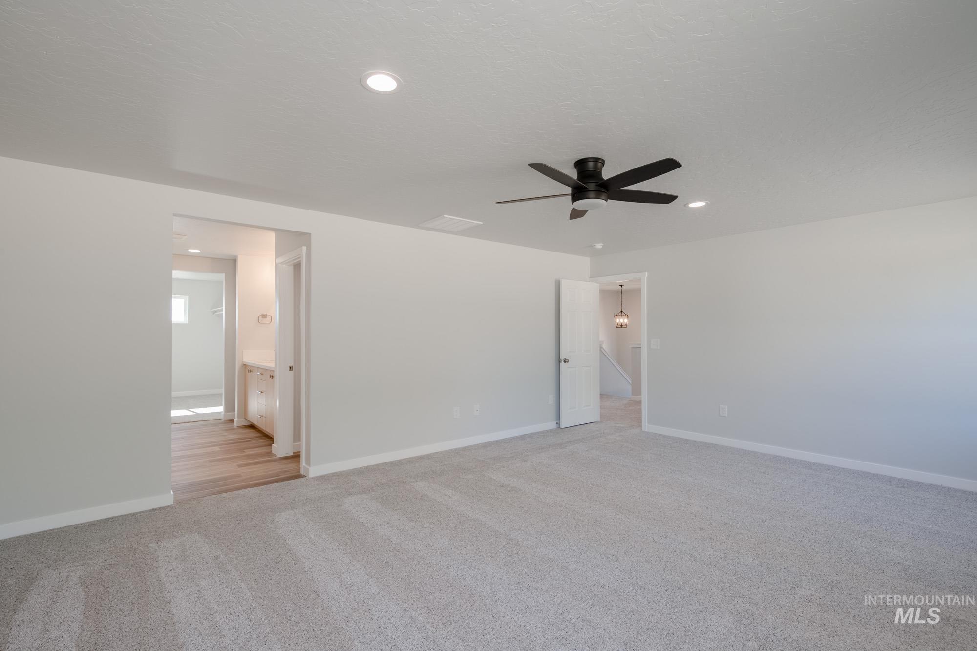Unfurnished bedroom featuring light colored carpet, recessed lighting, a ceiling fan, and connected bathroom