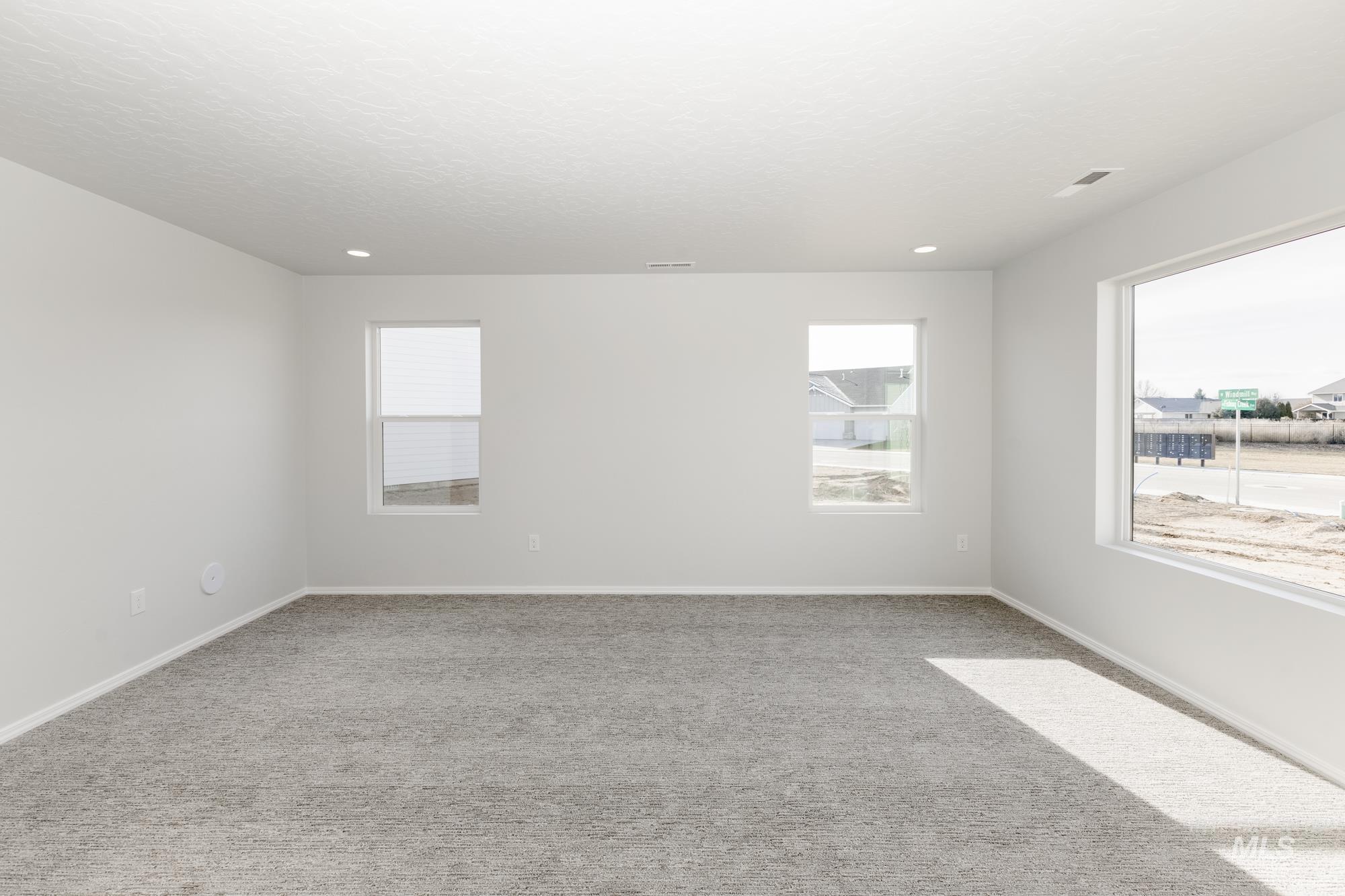 Unfurnished room with light colored carpet and a textured ceiling