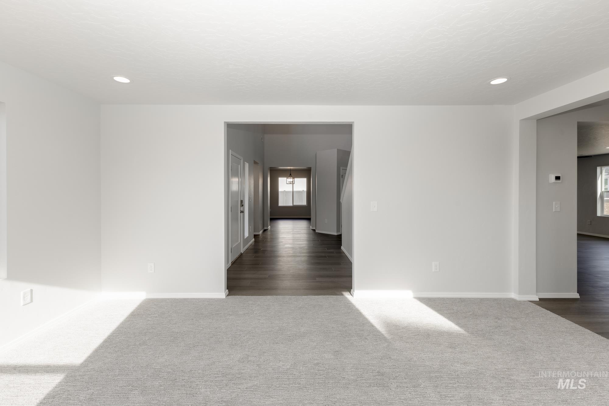 Unfurnished room with dark carpet, recessed lighting, and a textured ceiling