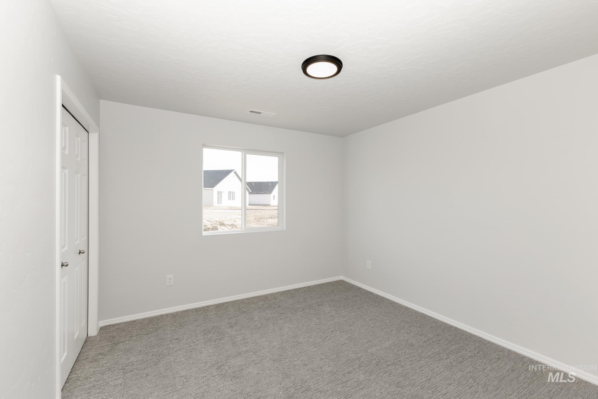 Unfurnished bedroom with carpet, a closet, and a textured ceiling