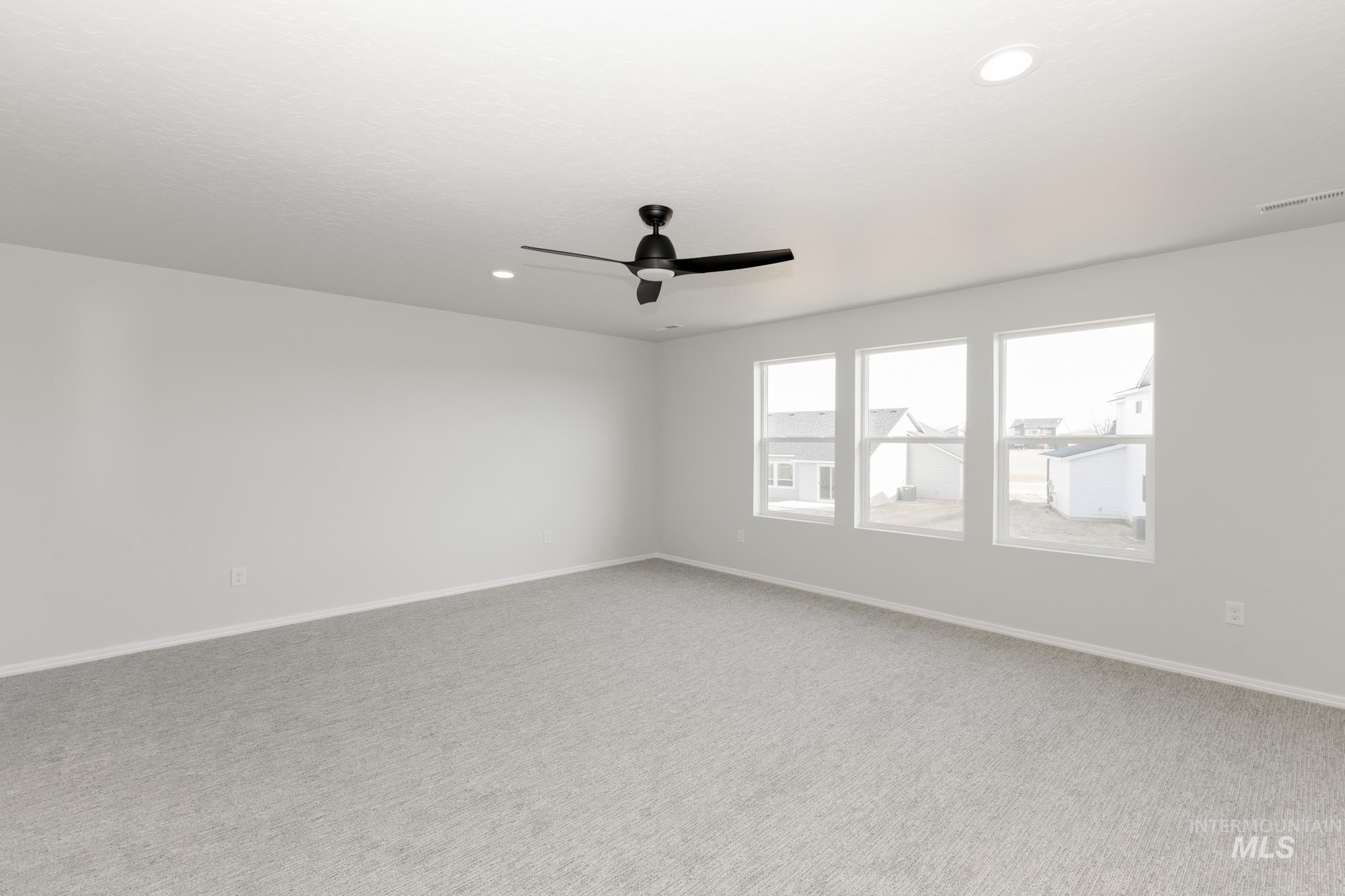 Carpeted spare room featuring ceiling fan and recessed lighting