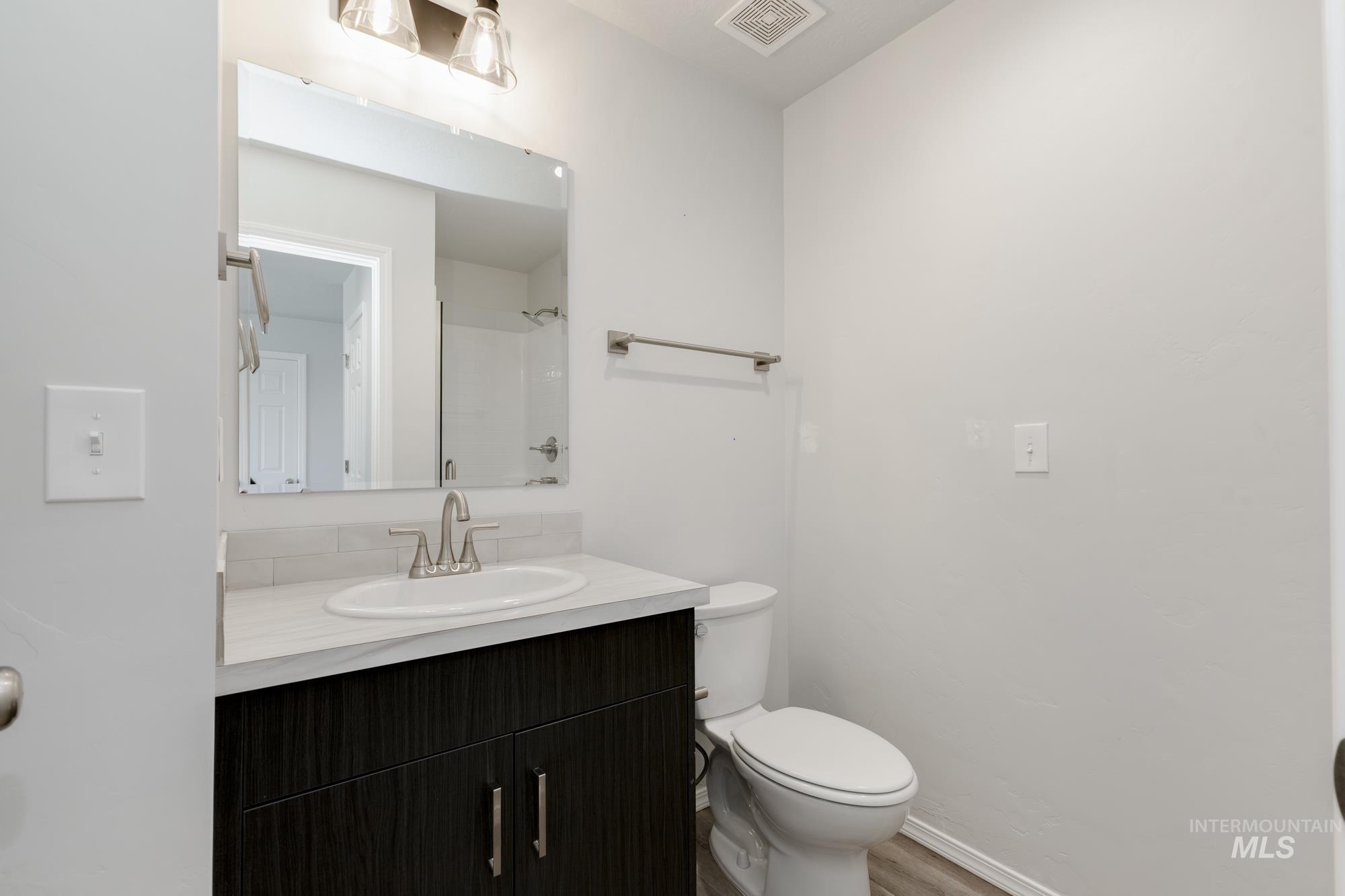 Bathroom with vanity, a shower, and light wood-style floors