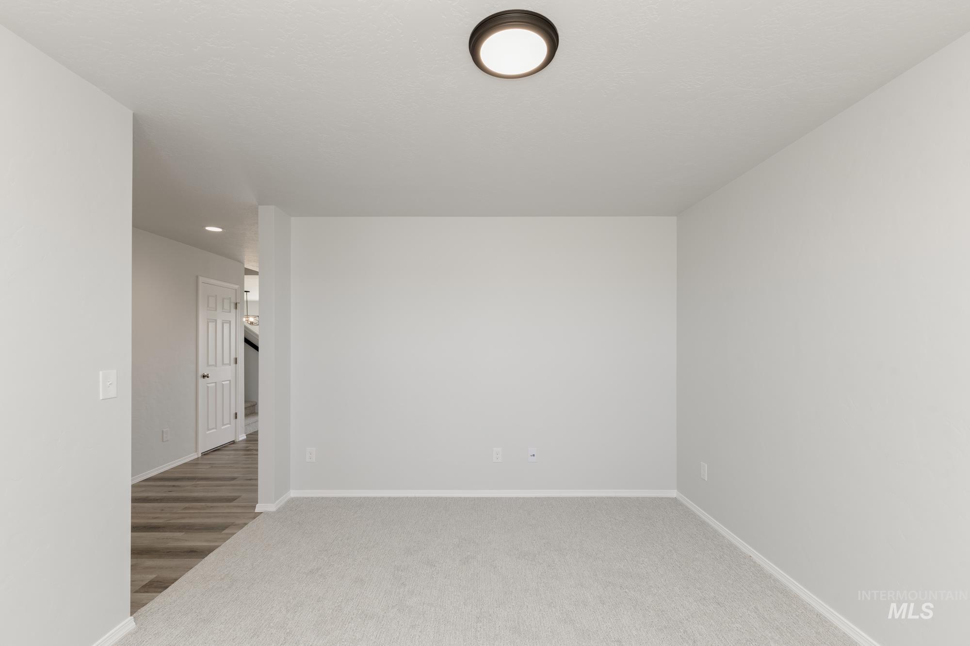 Spare room featuring baseboards and light colored carpet