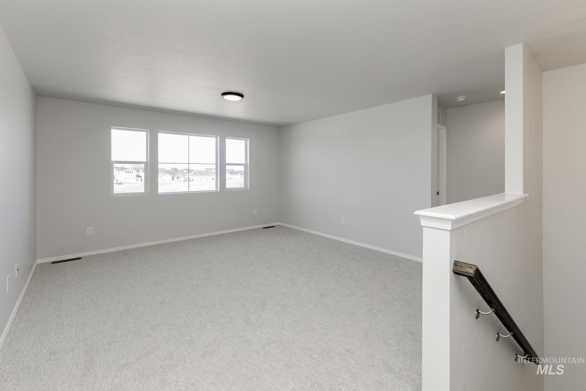 Spare room featuring light carpet and baseboards