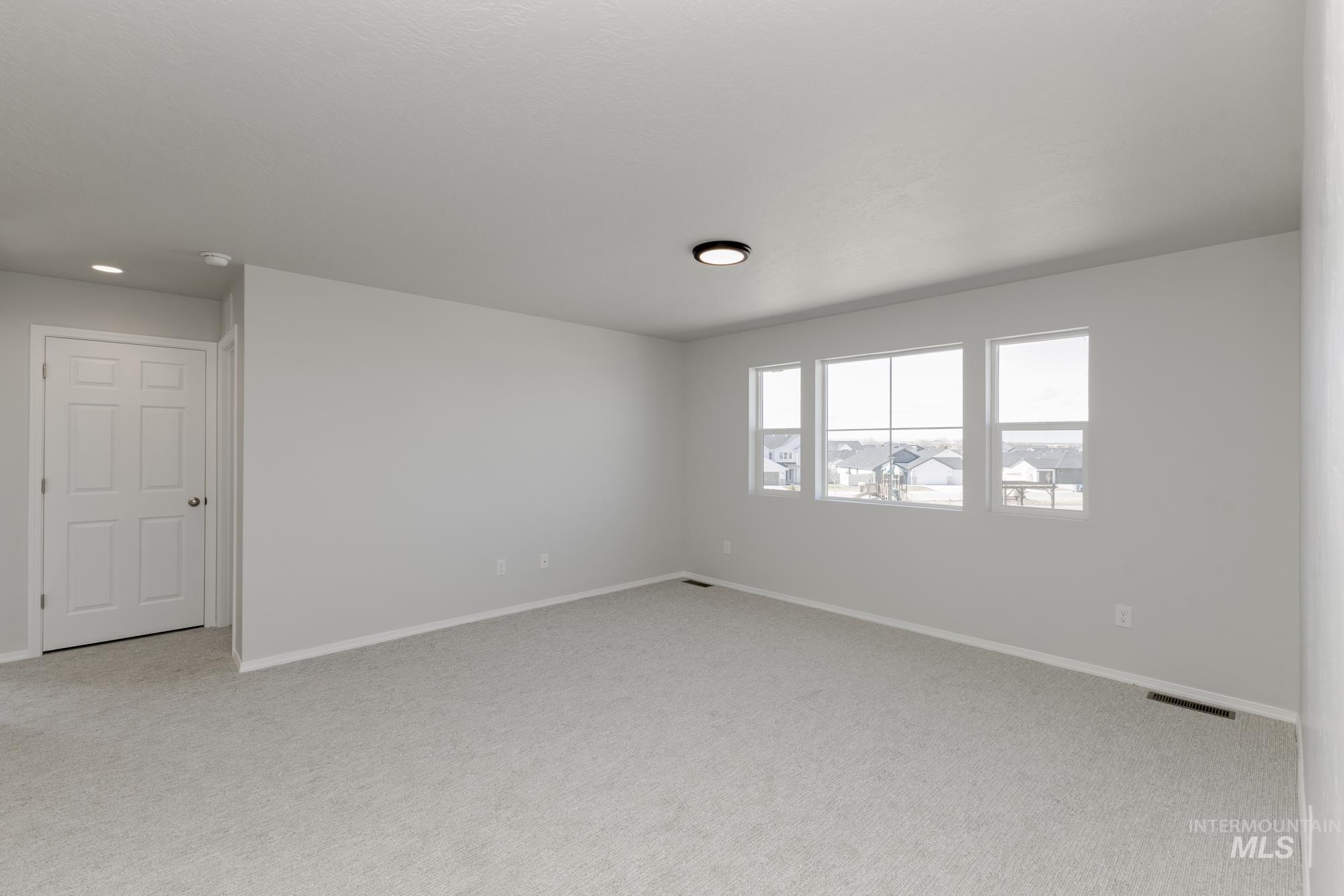 Unfurnished room featuring baseboards and light colored carpet
