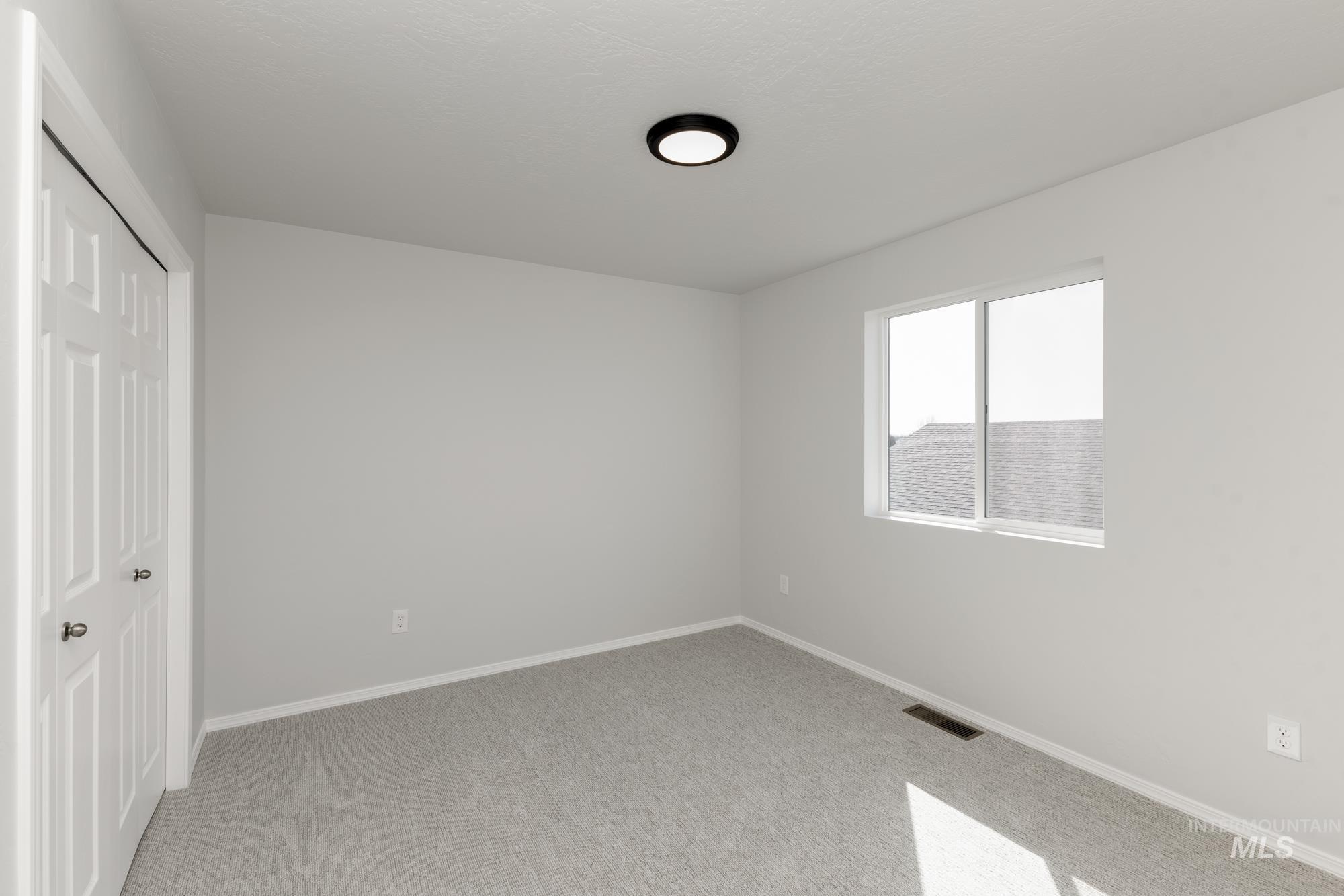 Unfurnished bedroom featuring a closet and light colored carpet
