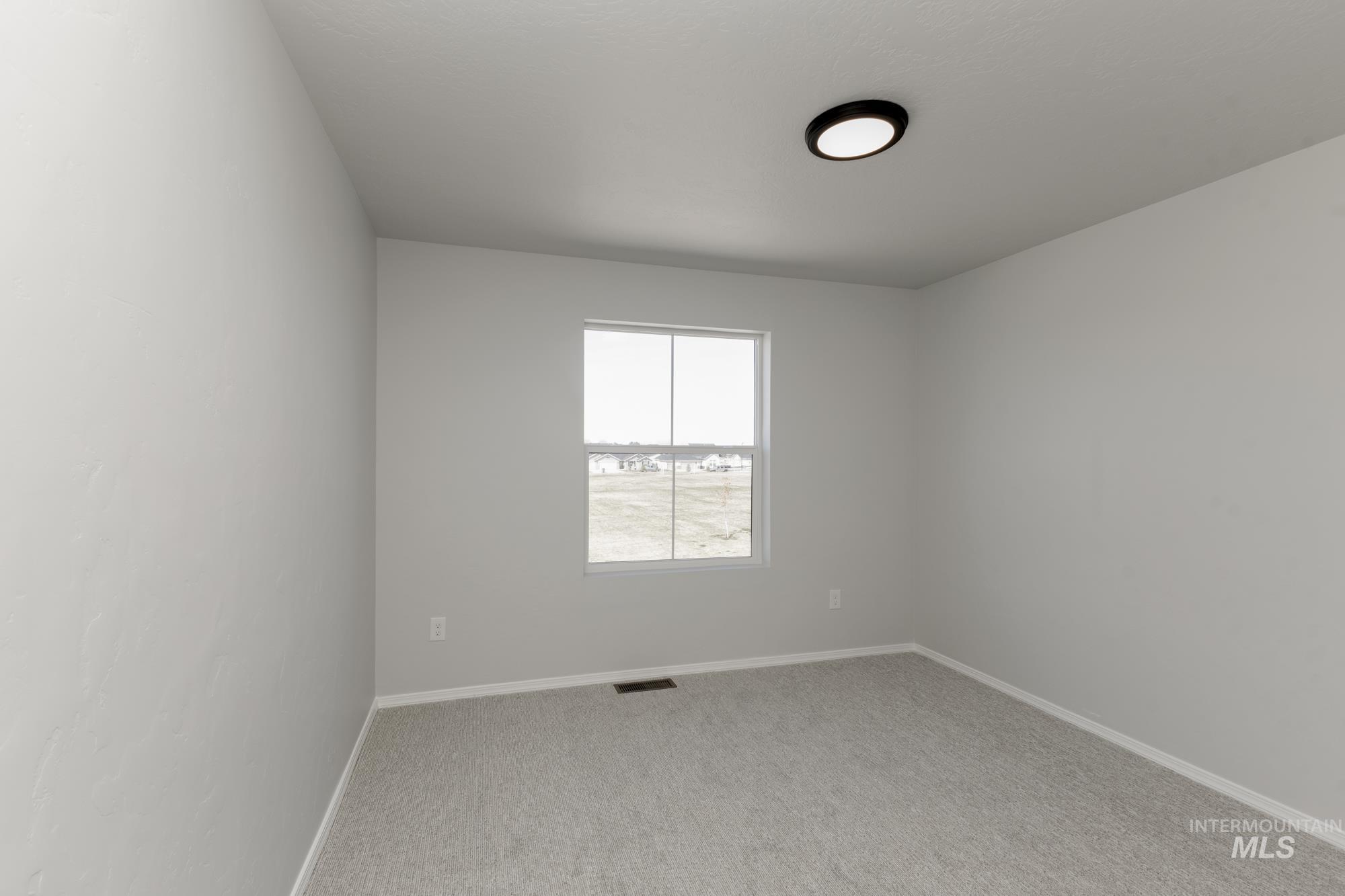 Unfurnished room with baseboards and light carpet