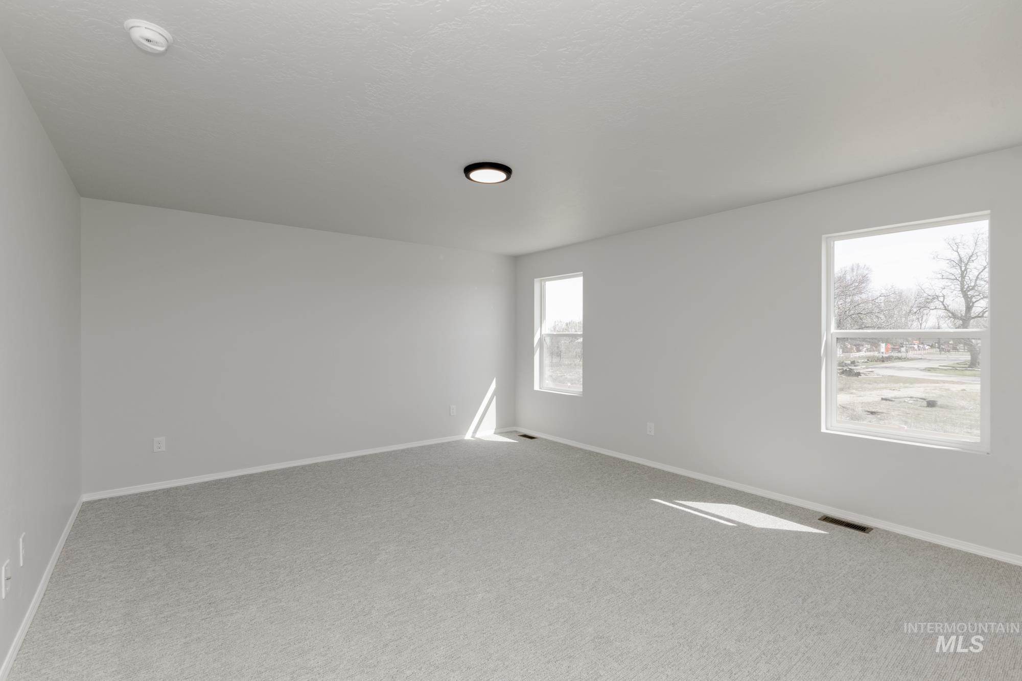 Empty room with carpet floors and baseboards