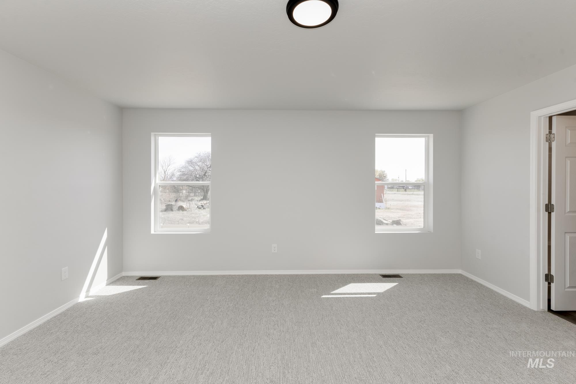 Carpeted spare room with plenty of natural light