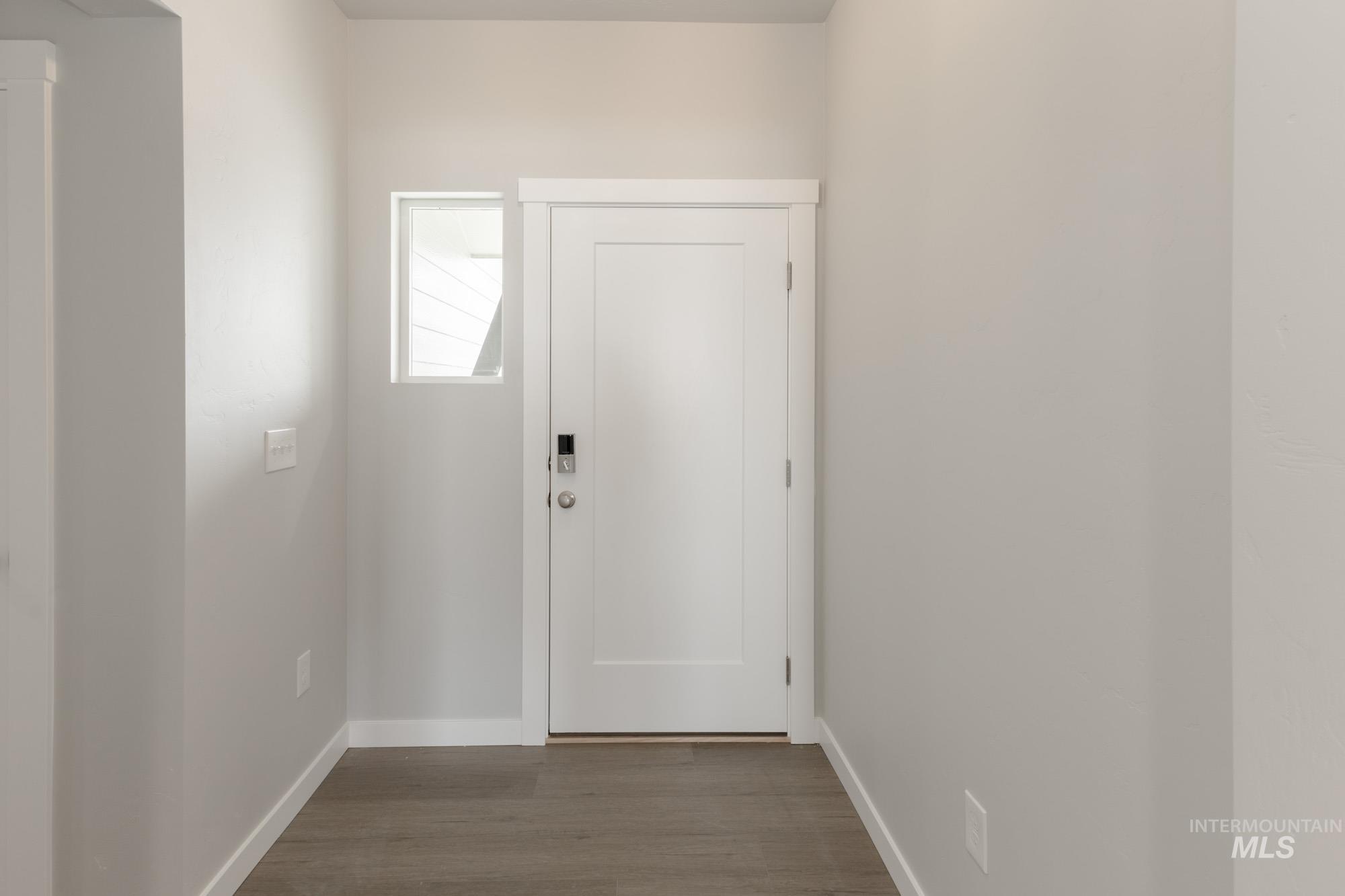 Entryway featuring baseboards and wood finished floors