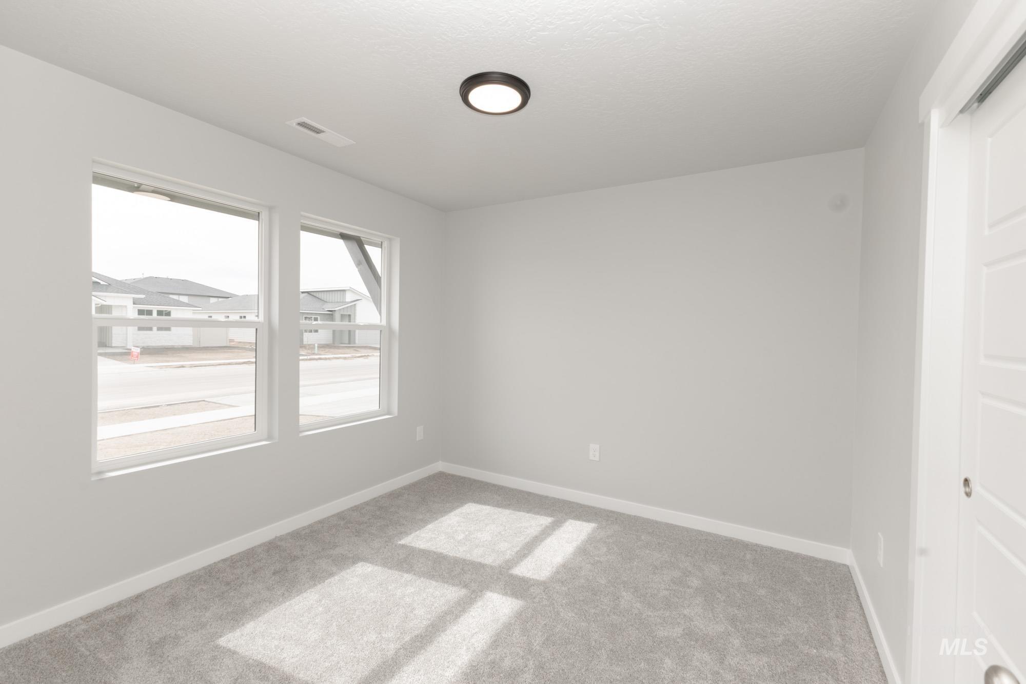 Unfurnished room with light colored carpet and baseboards