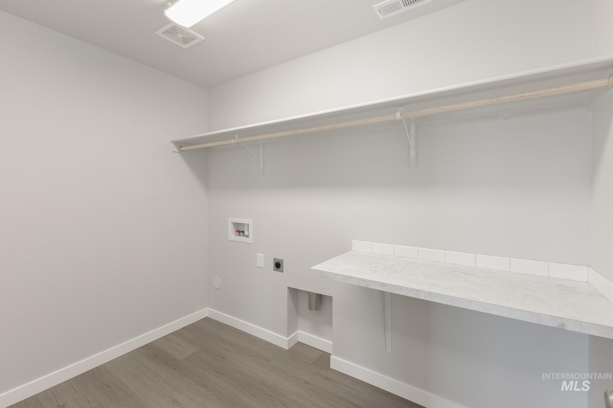 Laundry area with light wood-style flooring, electric dryer hookup, and hookup for a washing machine