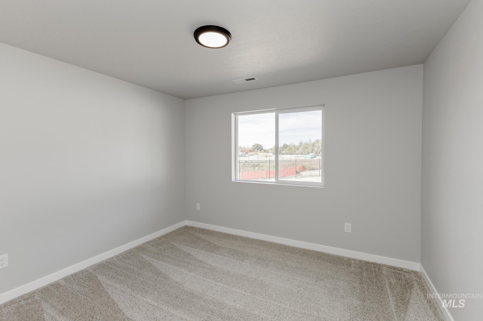 Empty room featuring carpet and baseboards