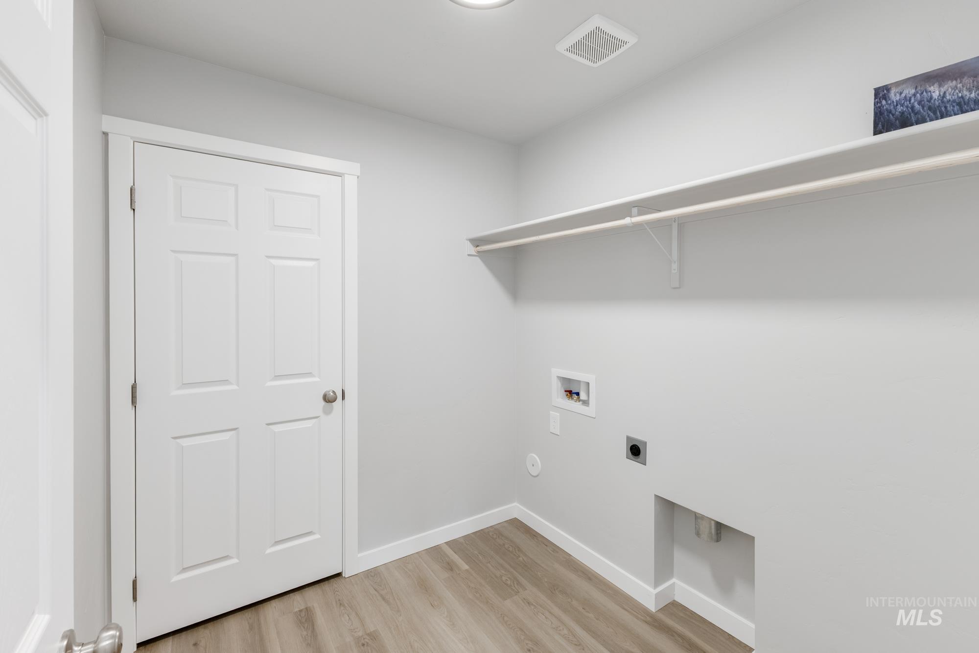 Laundry area featuring light wood-type flooring, hookup for an electric dryer, and hookup for a washing machine