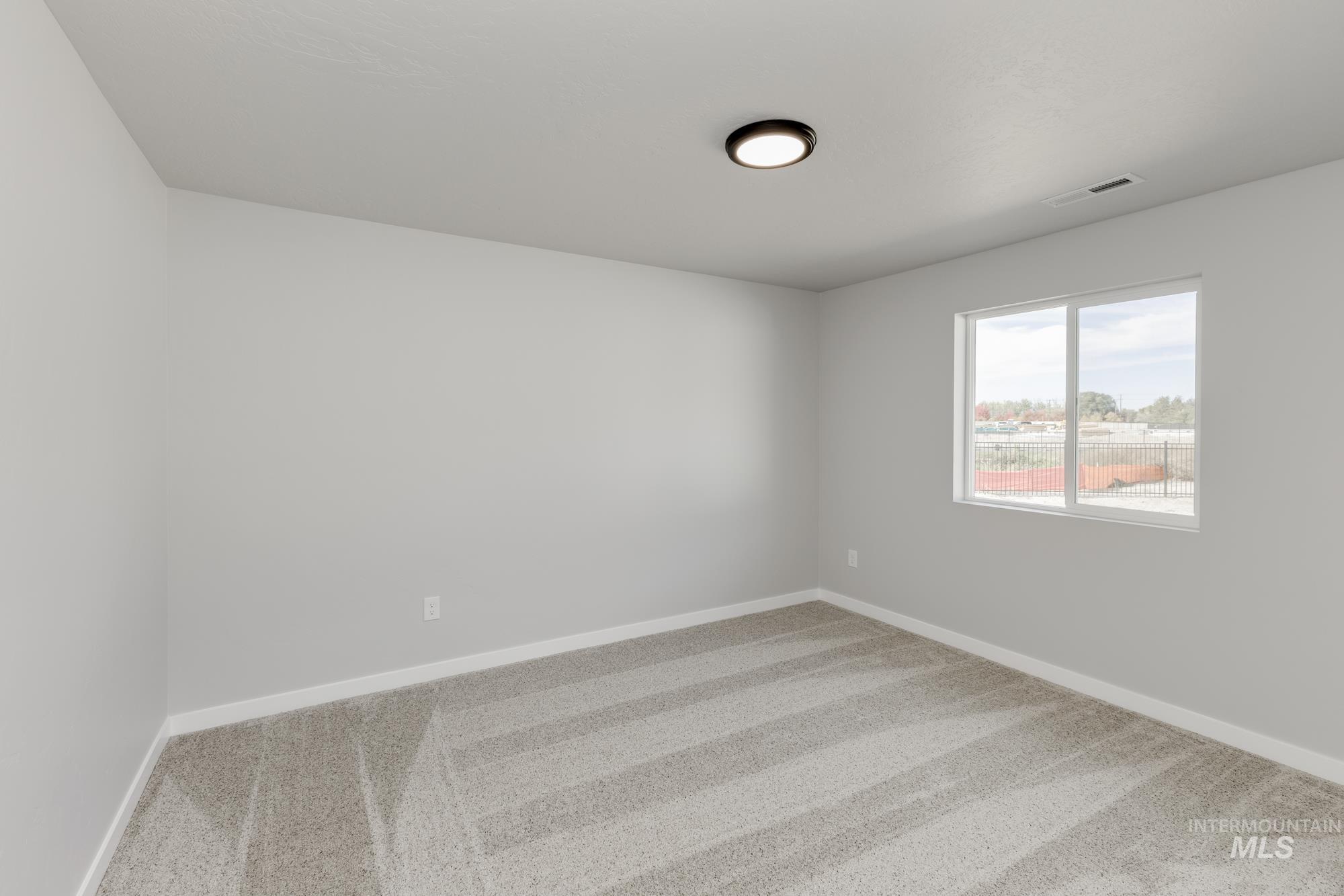 Spare room featuring carpet and baseboards