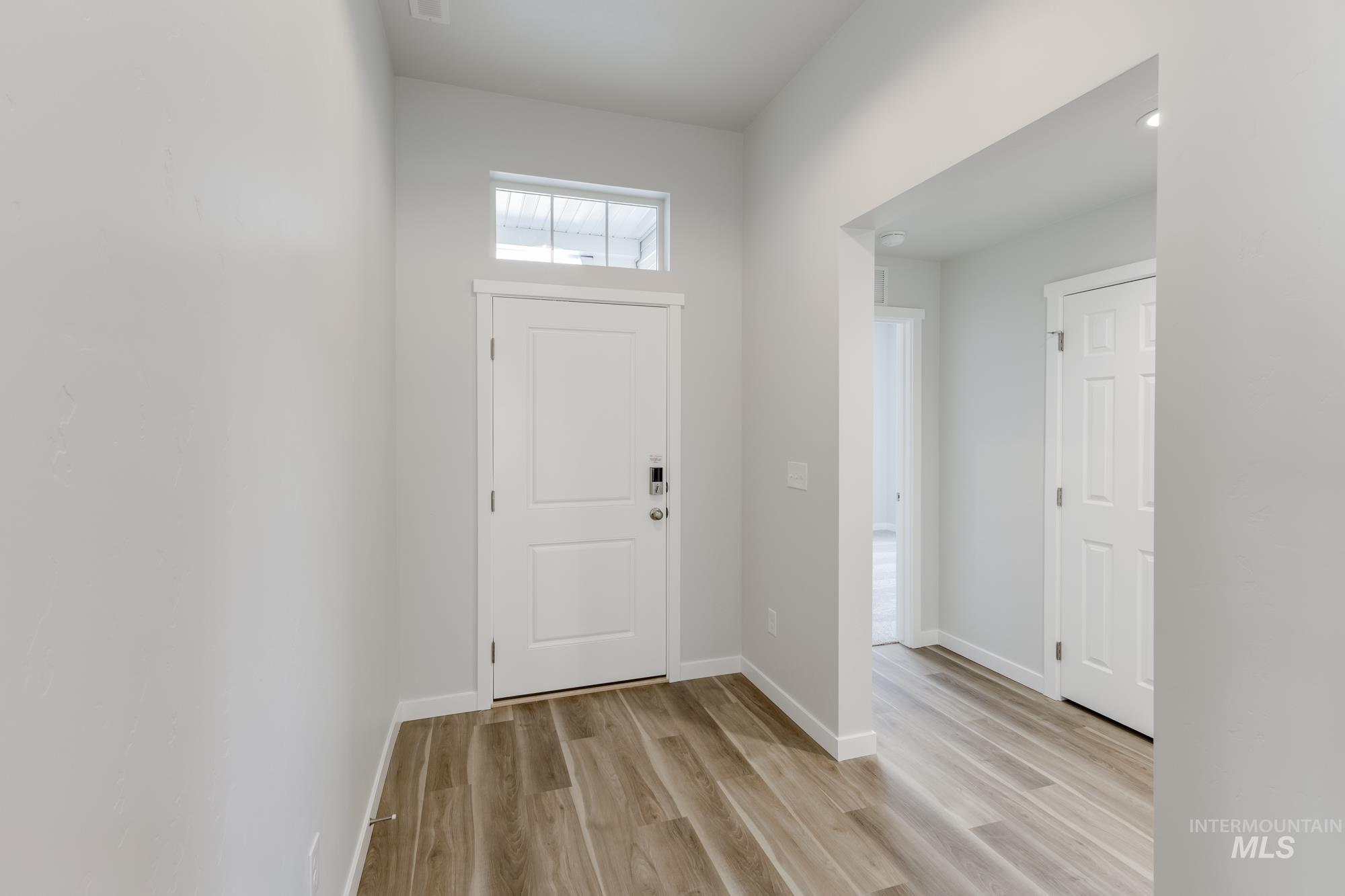 Foyer entrance featuring light wood-style floors and baseboards