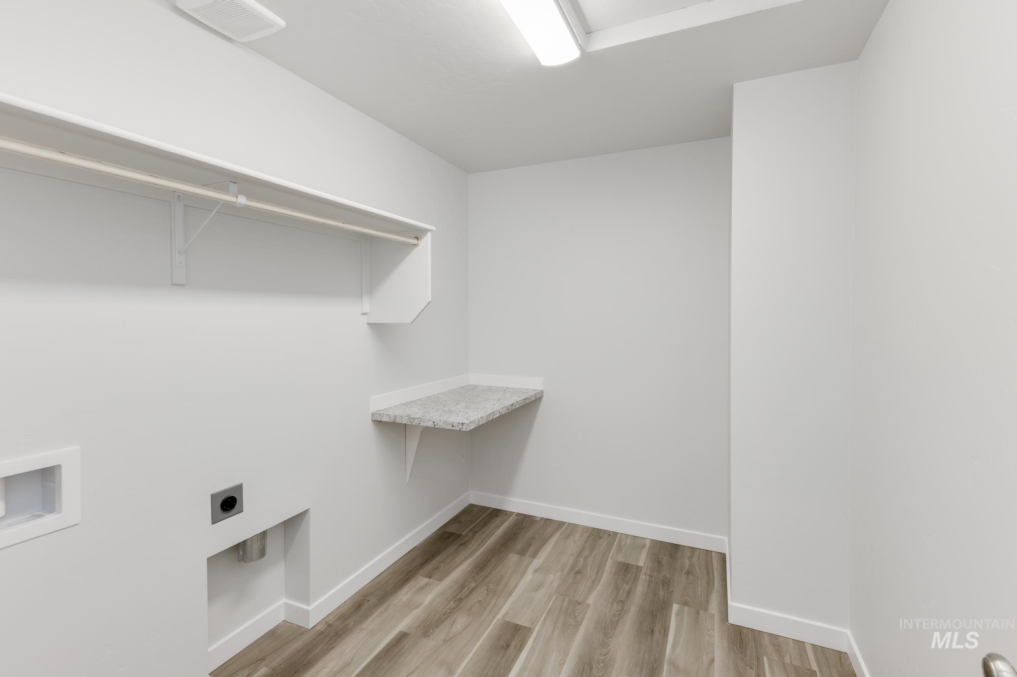 Washroom featuring light wood-style flooring, electric dryer hookup, and hookup for a washing machine