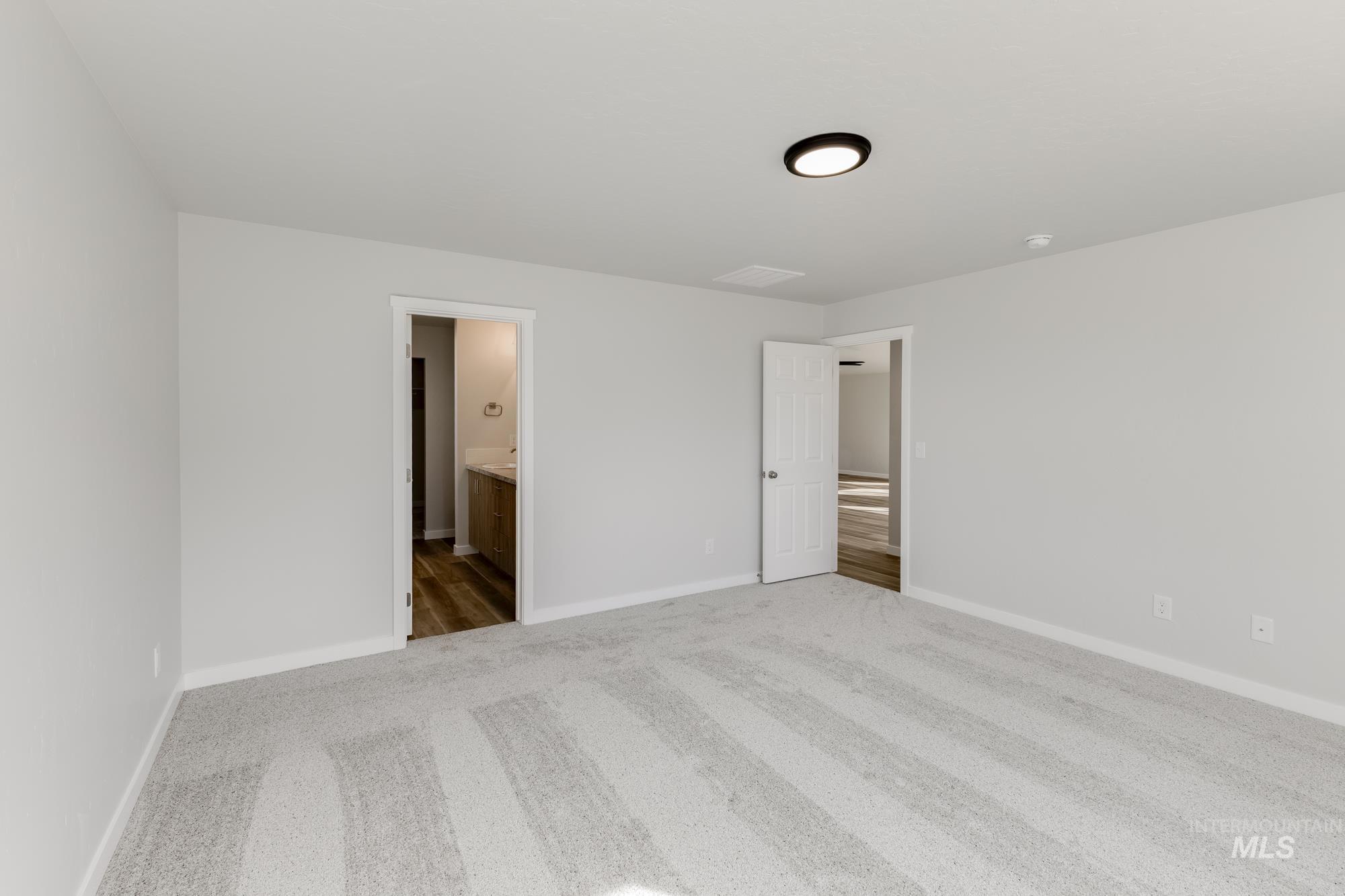 Unfurnished bedroom featuring carpet flooring and ensuite bathroom