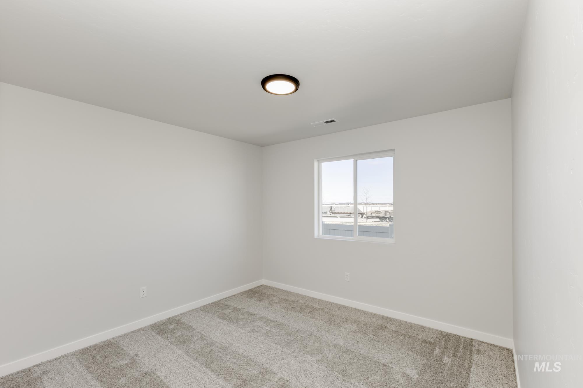 Carpeted spare room with baseboards