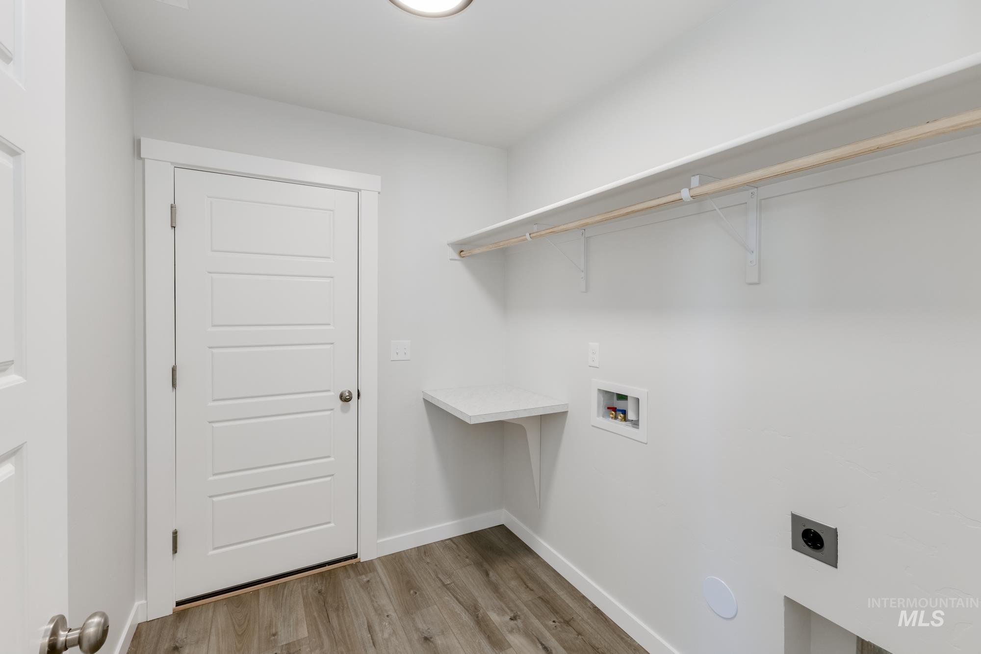 Washroom featuring light wood-style floors, hookup for a washing machine, and hookup for an electric dryer