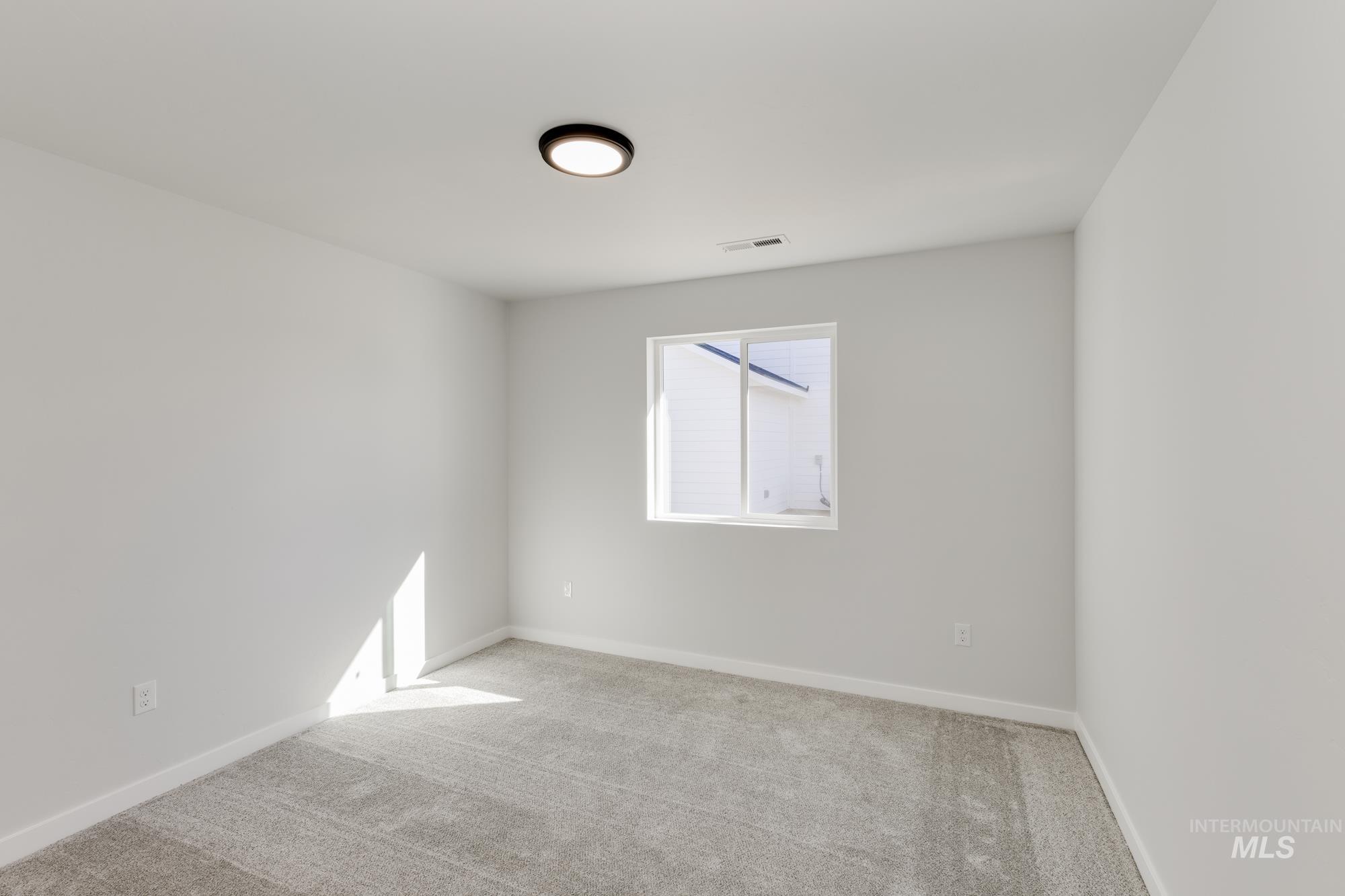 Carpeted spare room with baseboards