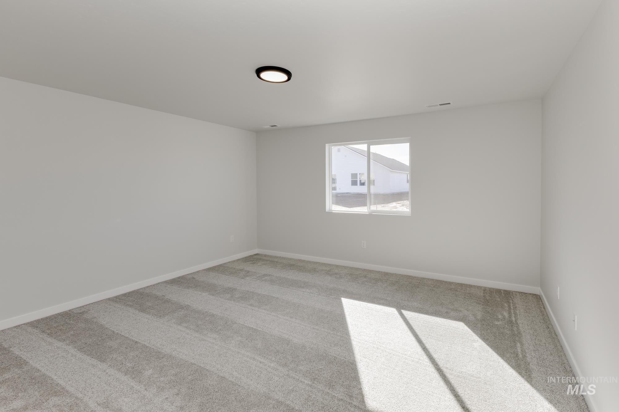 Carpeted empty room featuring baseboards